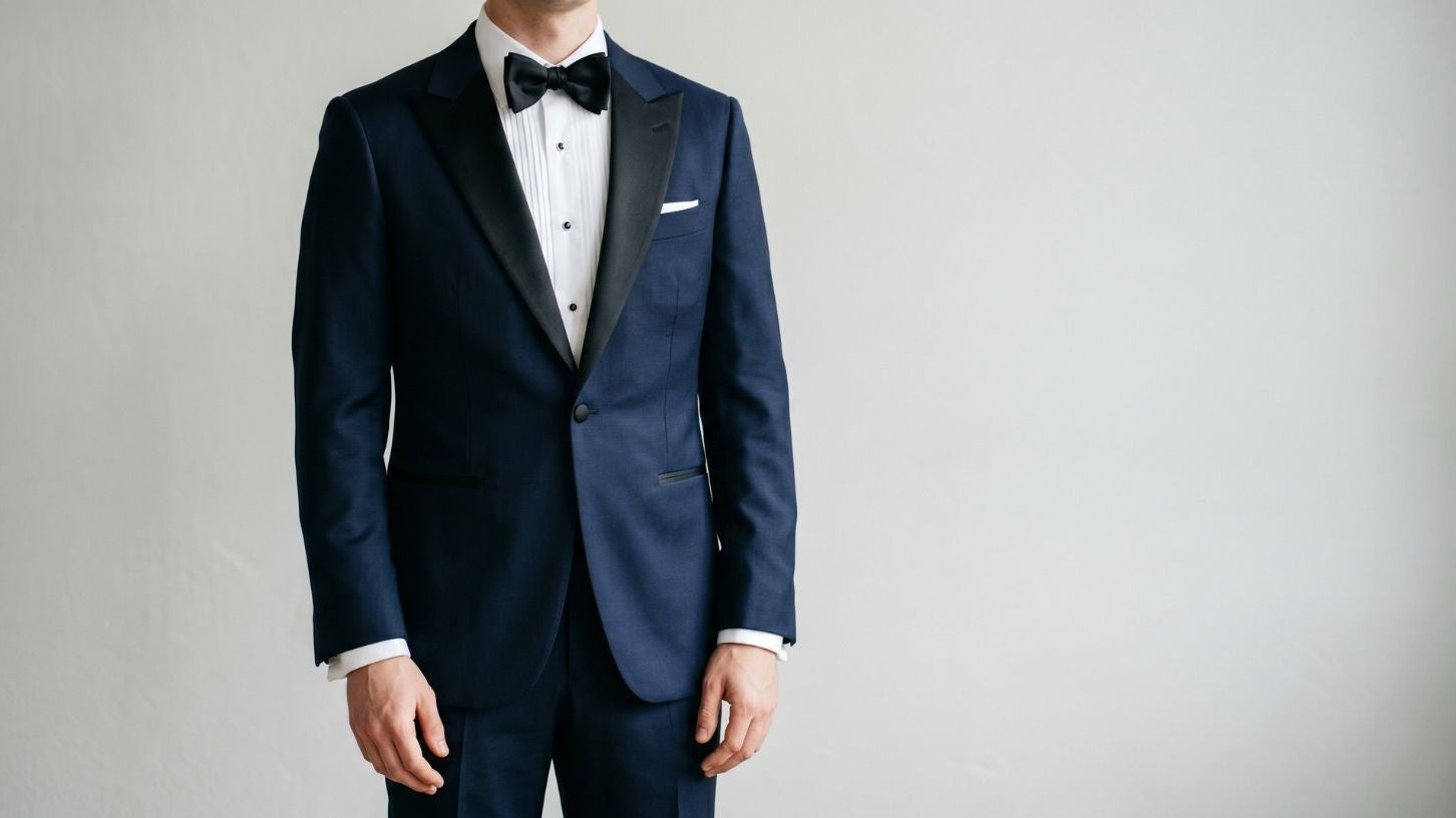 Navy tuxedo with black satin lapels and matching bow tie perfect for low light formal occasions