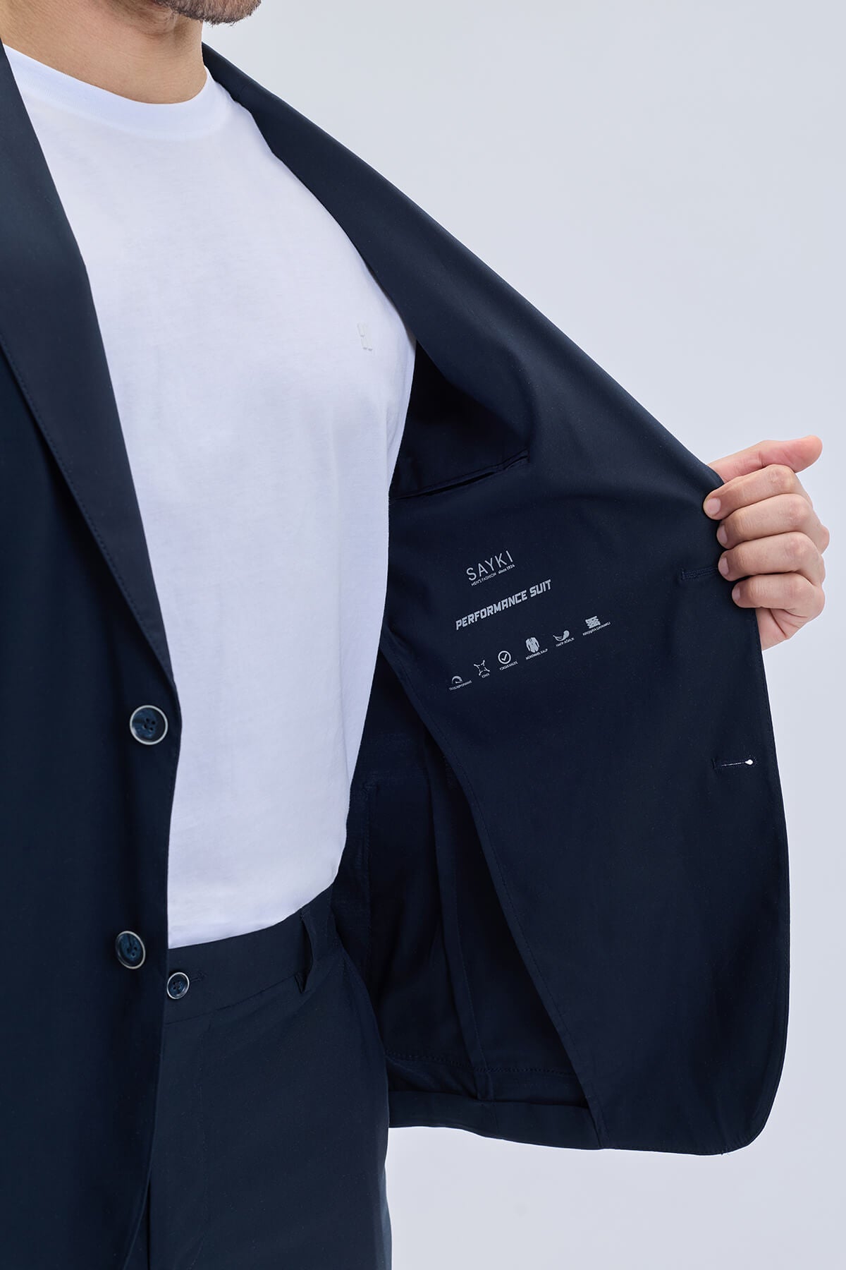 Slim fit notch lapel lightweight navy suit jacket with white embroidered branding and sleek button details