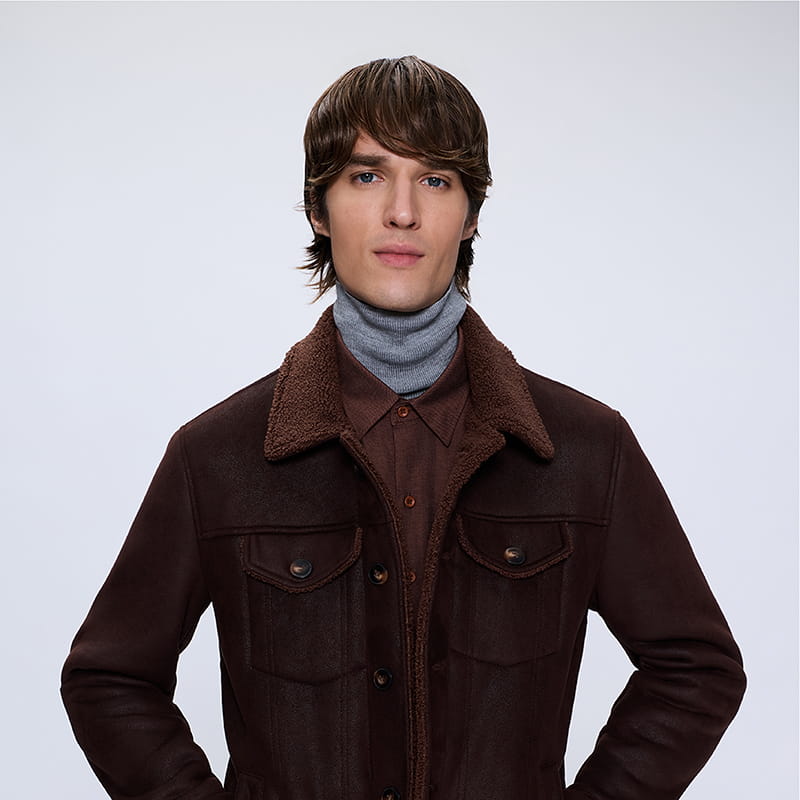 Man wearing brown jacket layered with knit and shirt, curated winter menswear gift collection