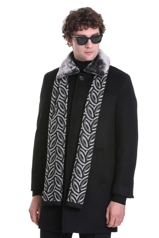 Black coat with a plush, gray-furred collar and a patterned scarf featuring interlocking oval designs in silver and black.