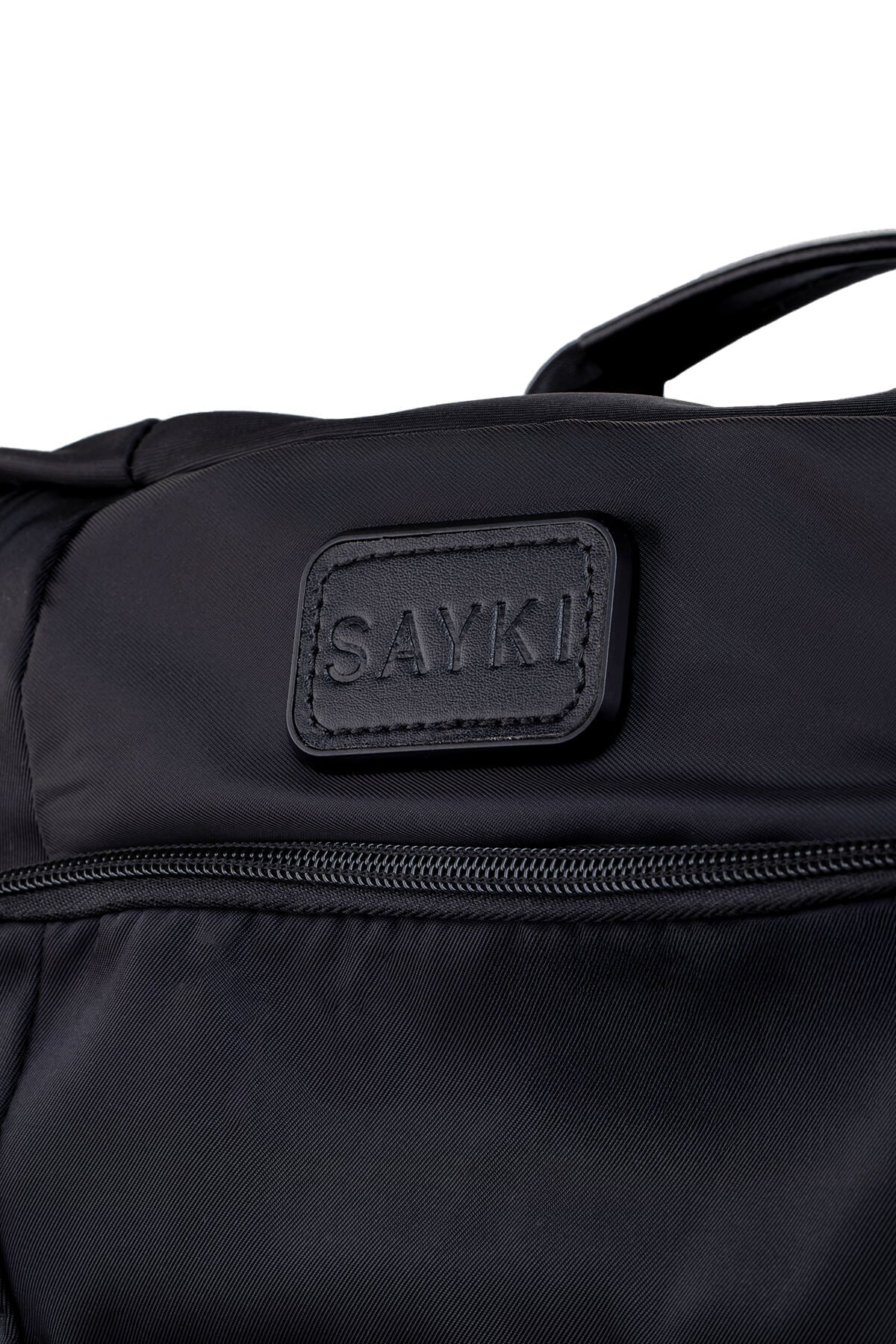 Black sayki brand duffel bag with a textured fabric body and stitched leather-like patch.