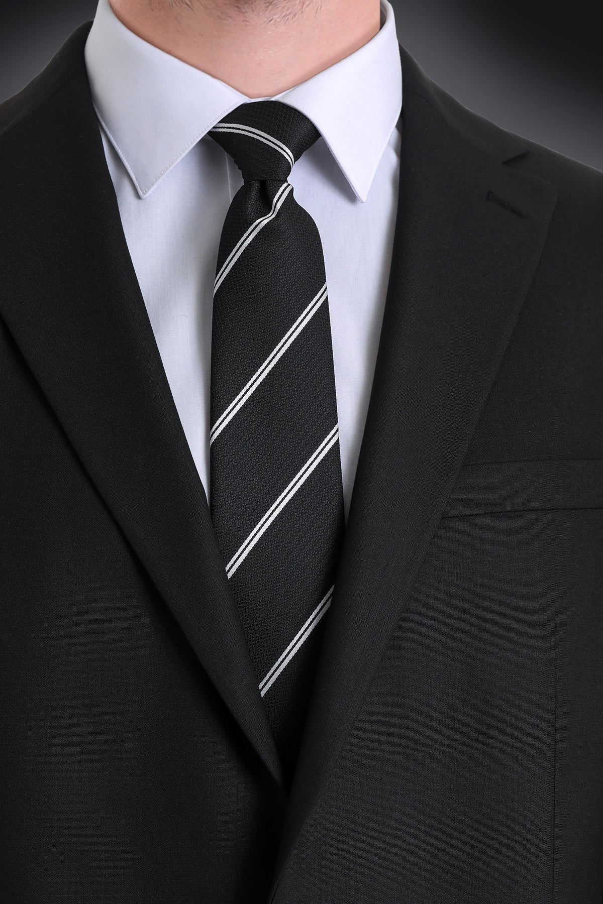 Black tie with thin white diagonal stripes, made of a textured fabric.