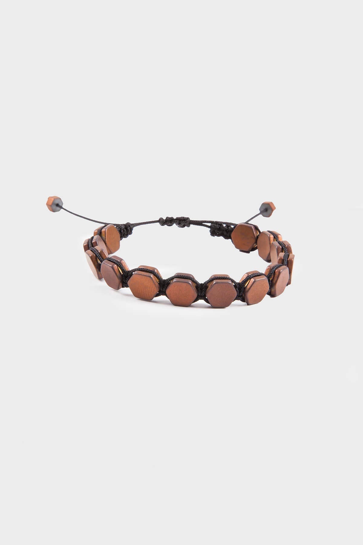 A brown, hexagonal-beaded bracelet with a black cord and adjustable sliding knots.