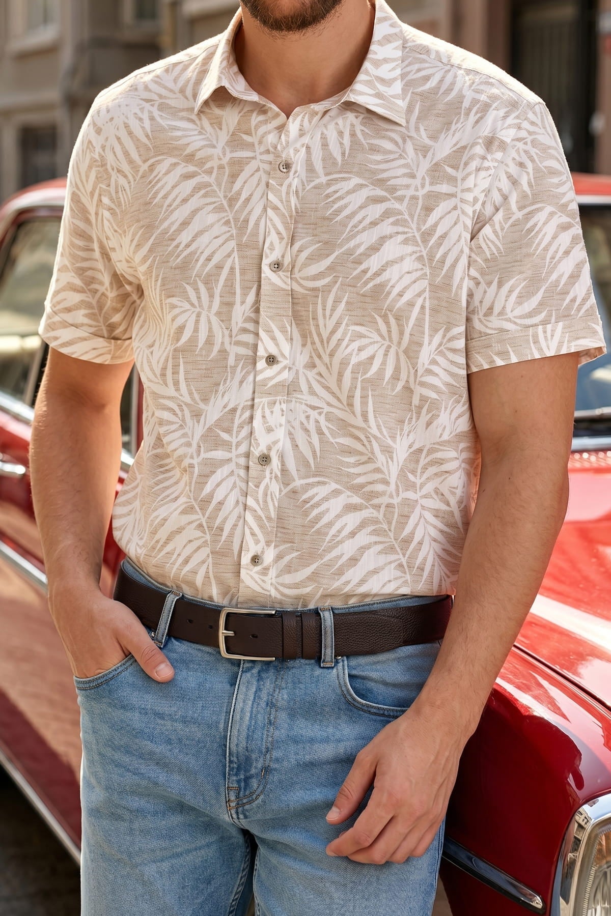 Beige short-sleeved button-down shirt with white palm leaf pattern paired with brown sport faux leather belt