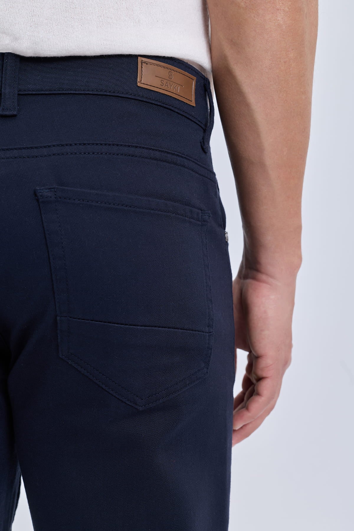 Dark navy blue cotton gabardine dynamic fit casual pants with a brown leather brand patch on the back waistband