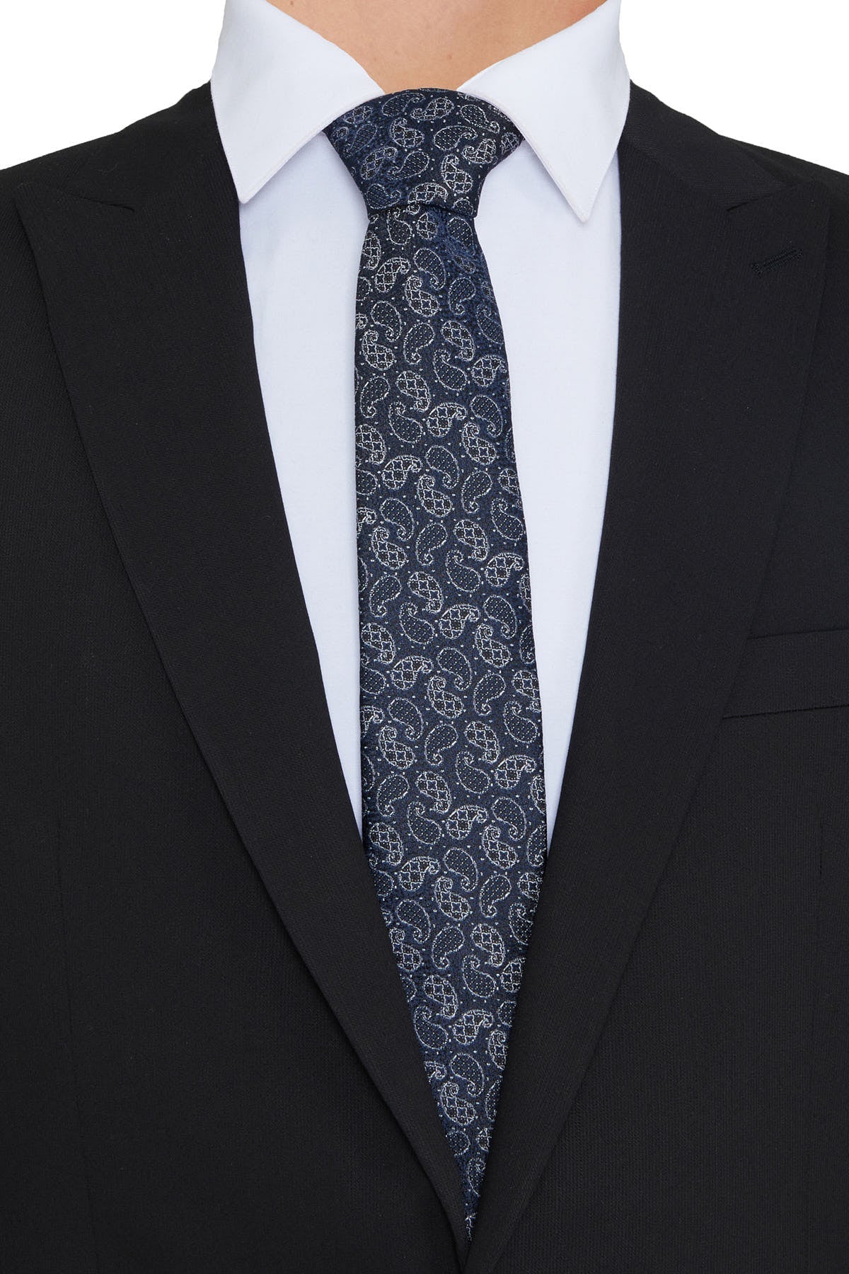 A navy blue tie with a subtle white paisley pattern, worn neatly knotted against a crisp white shirt and black suit.