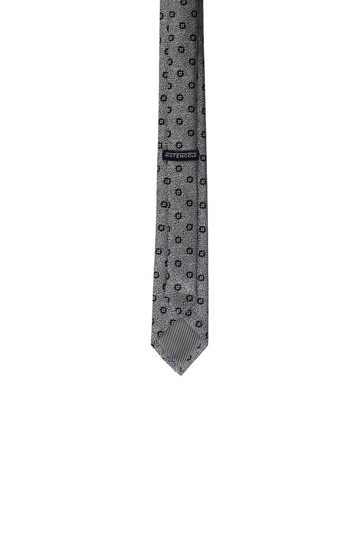 A sleek gray tie with a subtle geometric pattern and a branded label near the top.