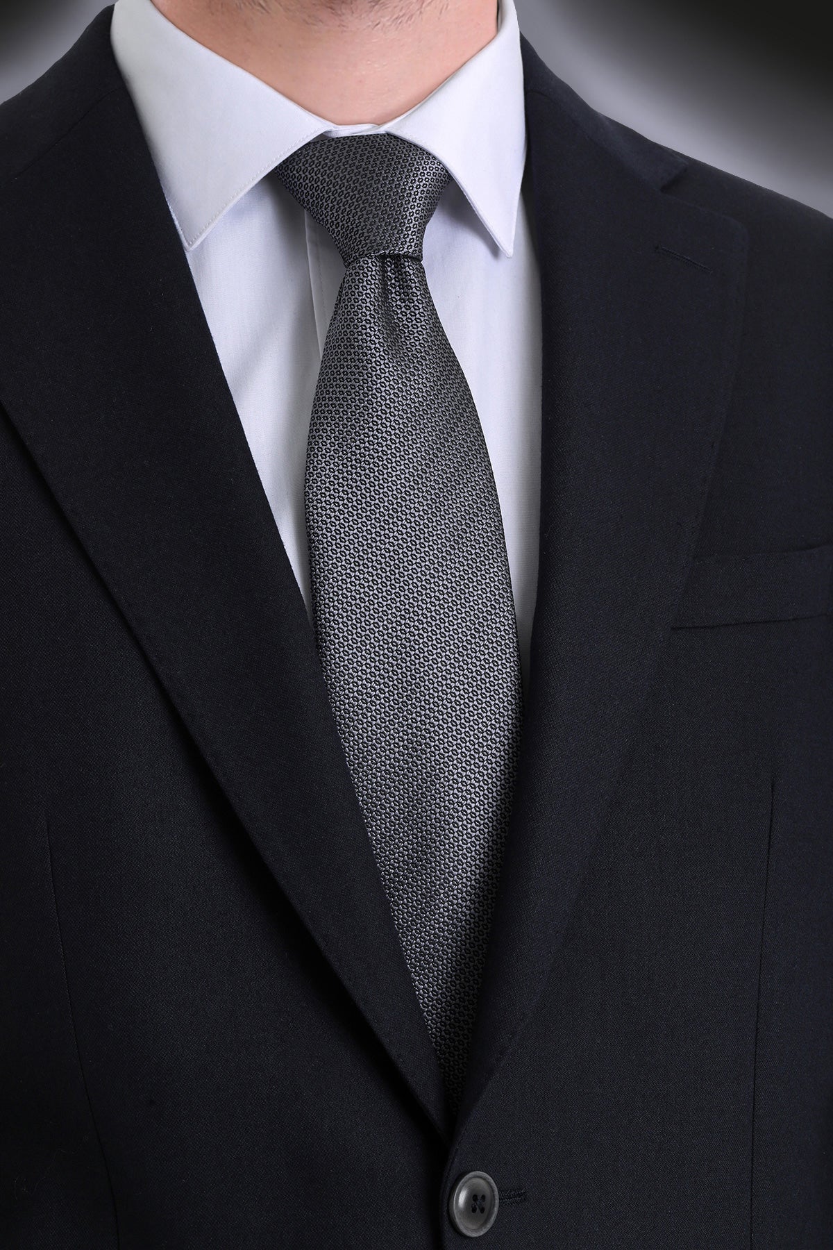 A sleek, dark gray tie with a subtle geometric pattern.