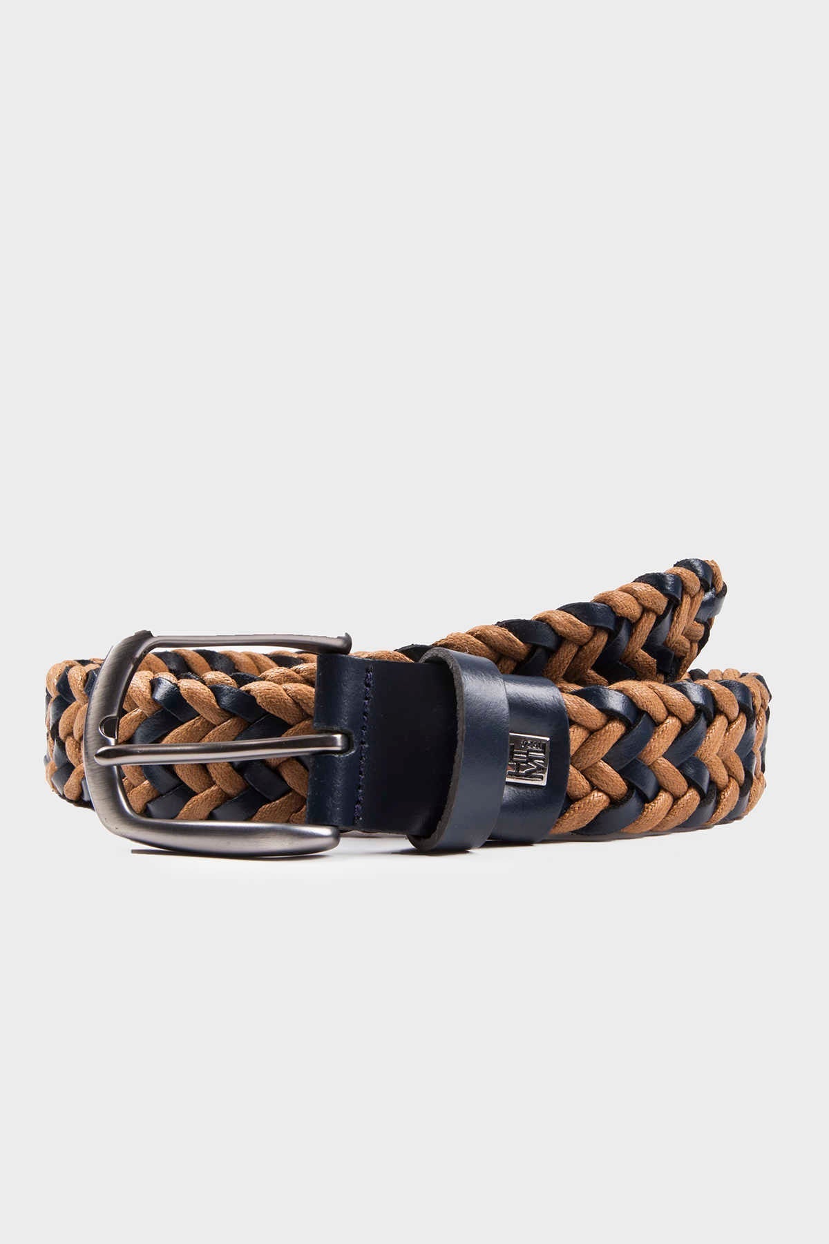 A braided belt with alternating tan and navy blue woven strands, featuring a silver-toned buckle and a matching leather tab.
