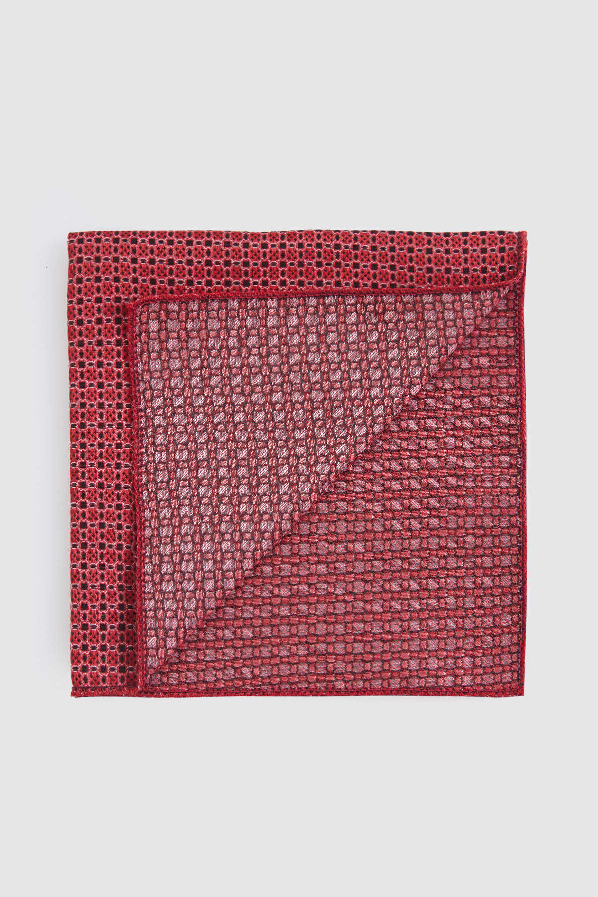 A rich red pocket square with a subtle woven geometric pattern and neatly finished edges.