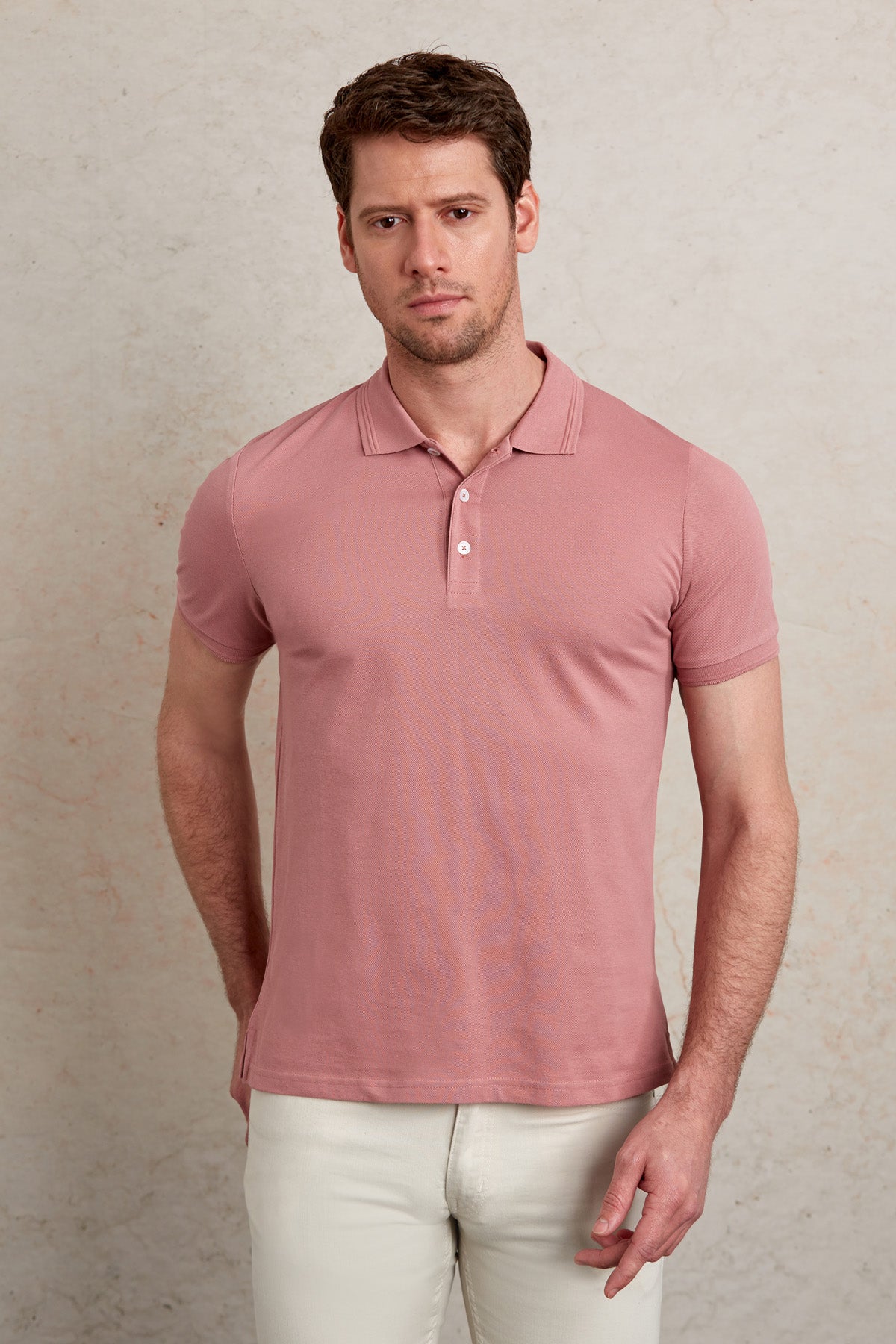 A soft pink short-sleeved polo shirt with a classic collar and buttoned placket.