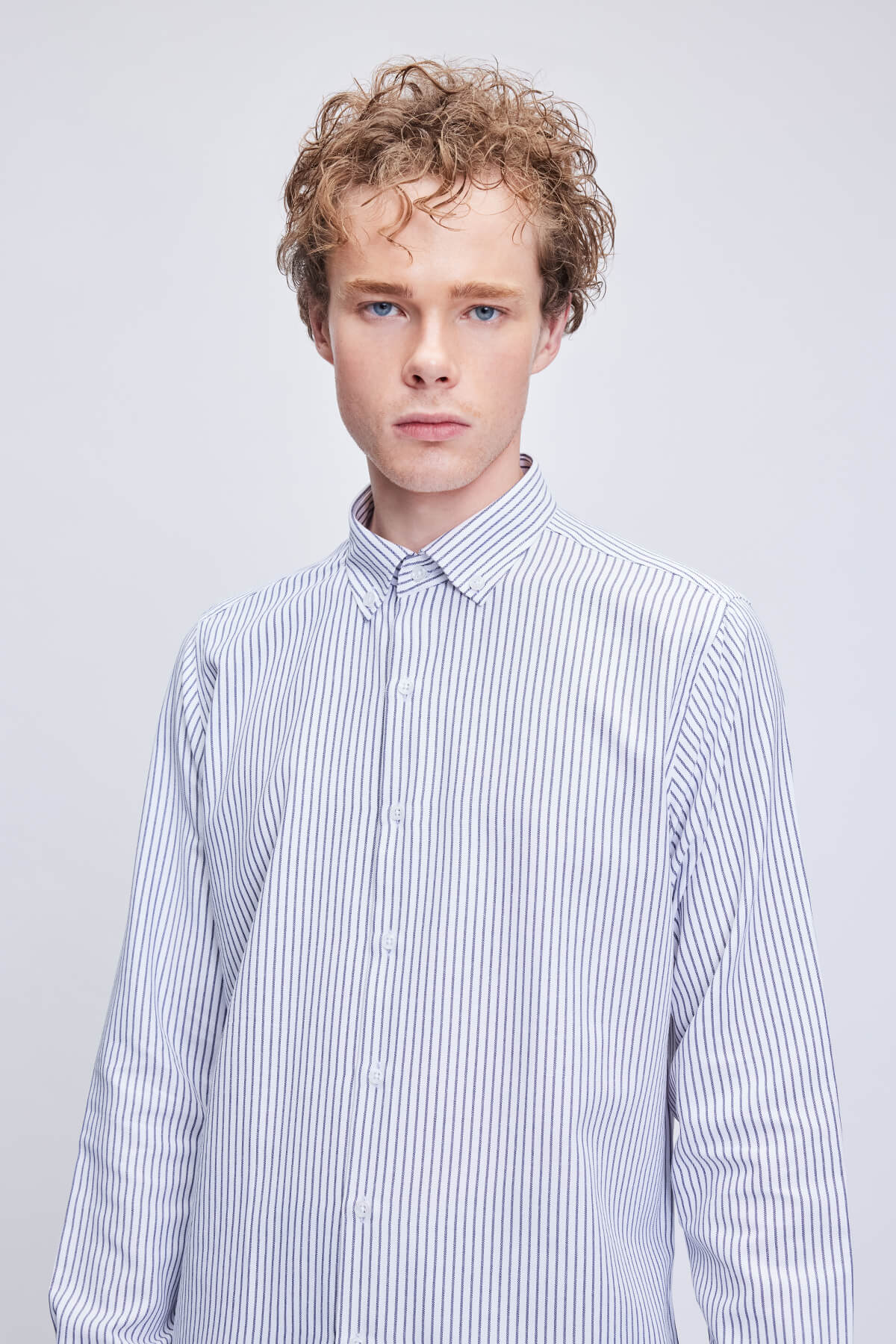 A crisp, long-sleeved button-down shirt in a classic white and navy blue vertical stripe pattern.