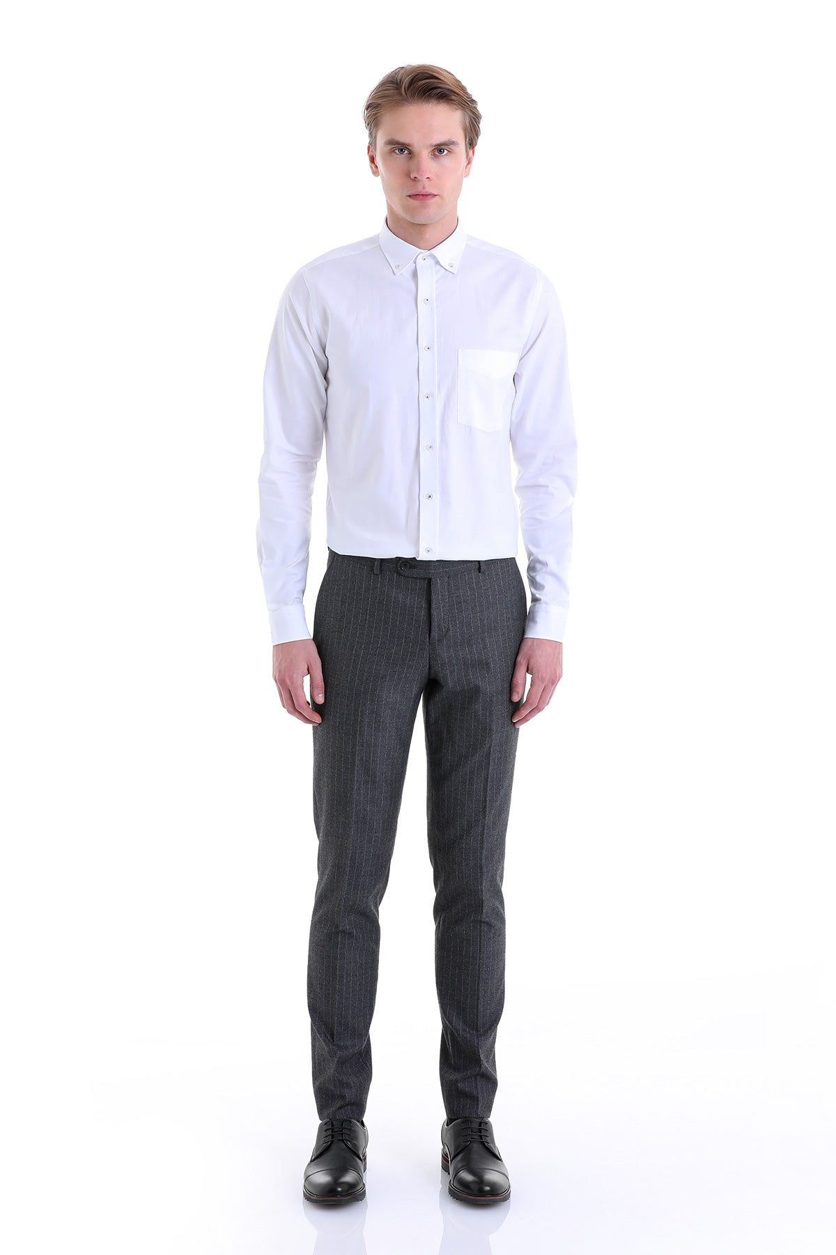A crisp white long-sleeved button-down shirt with a single chest pocket, paired with dark gray pinstripe trousers.