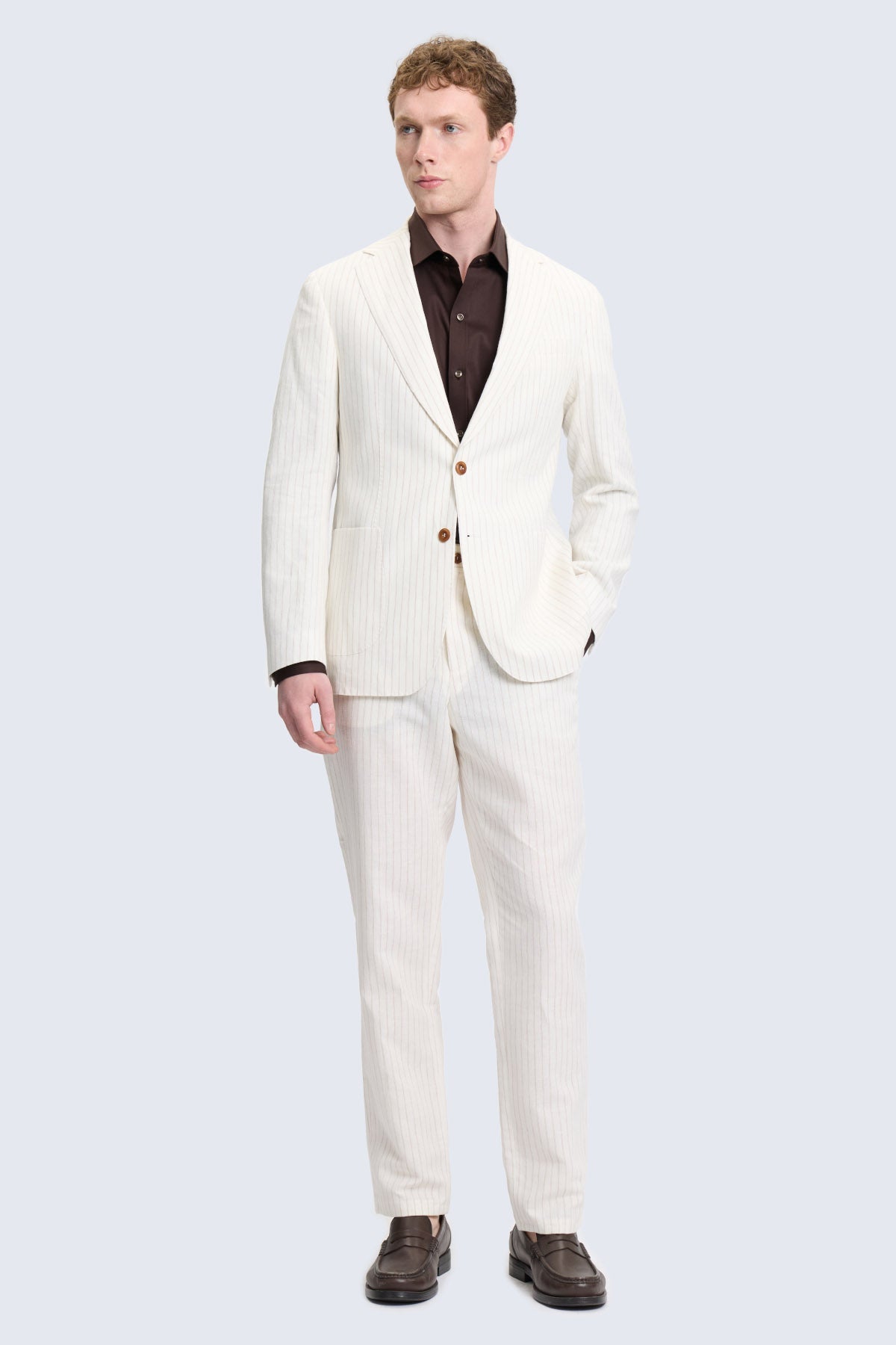 A crisp white textured wool comfort fit ecru notch lapel suit with matching trousers worn over a dark brown shirt
