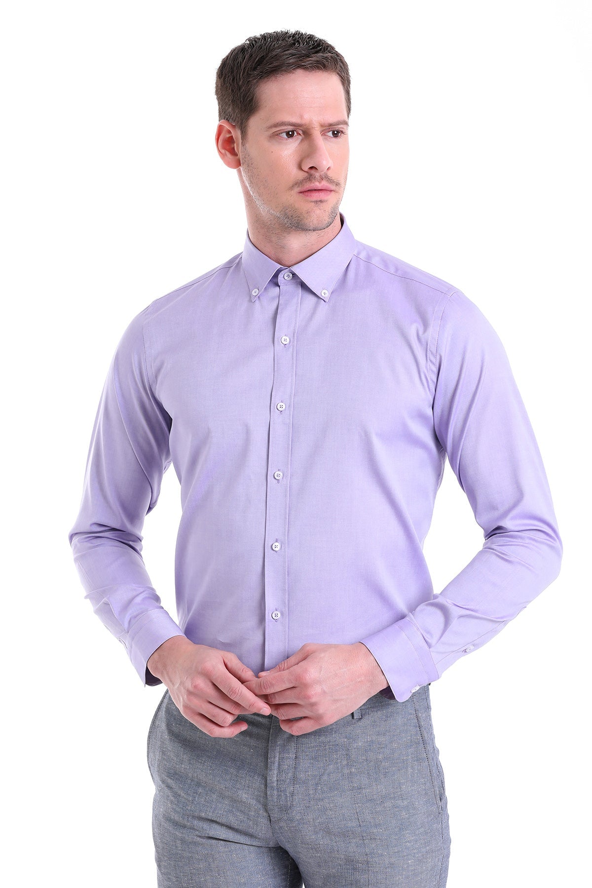 A man wearing a lavender long-sleeved button-down shirt with a classic collar and white buttons.