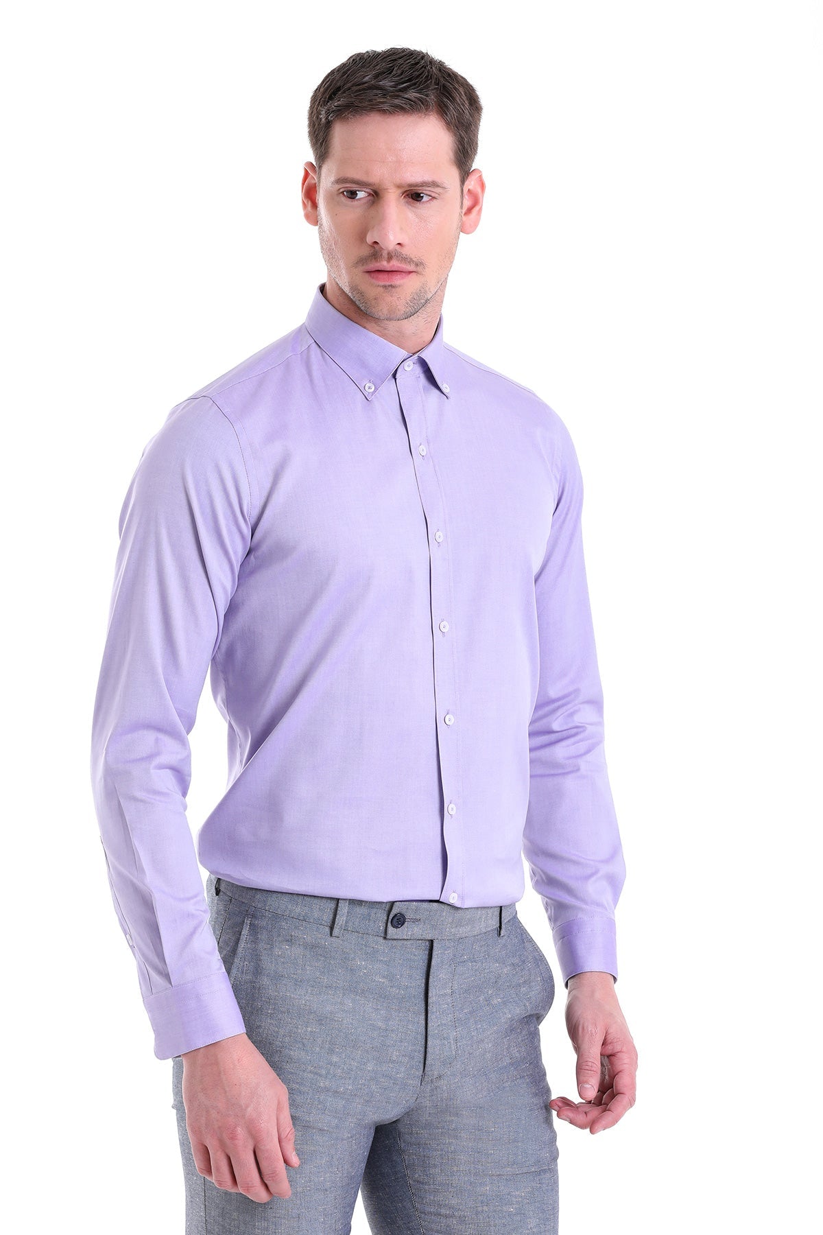 A man wearing a lavender long-sleeved button-down shirt with a classic collar and white buttons.