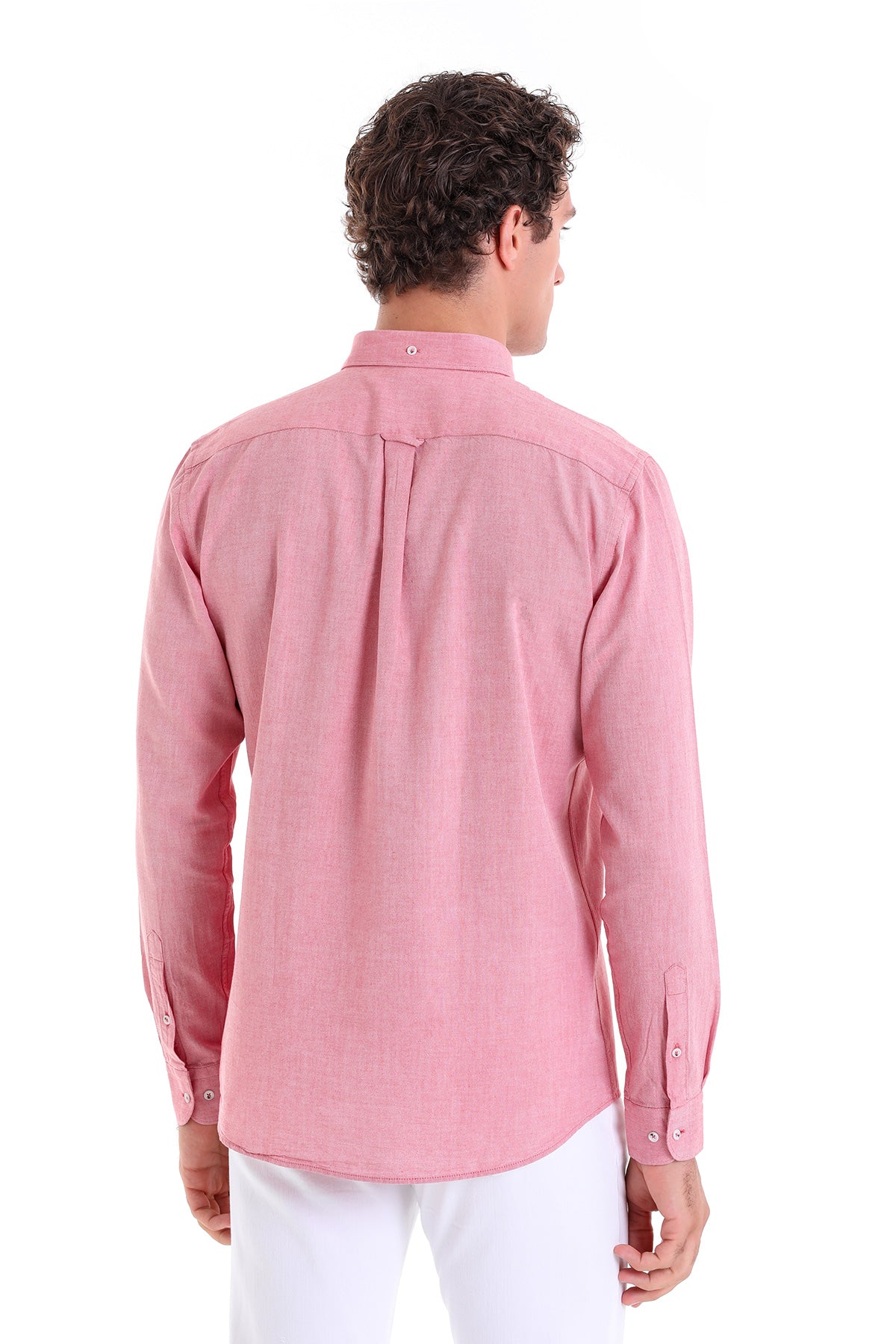 A man wearing a pink long-sleeved button-down shirt with a classic collar and subtle texture.