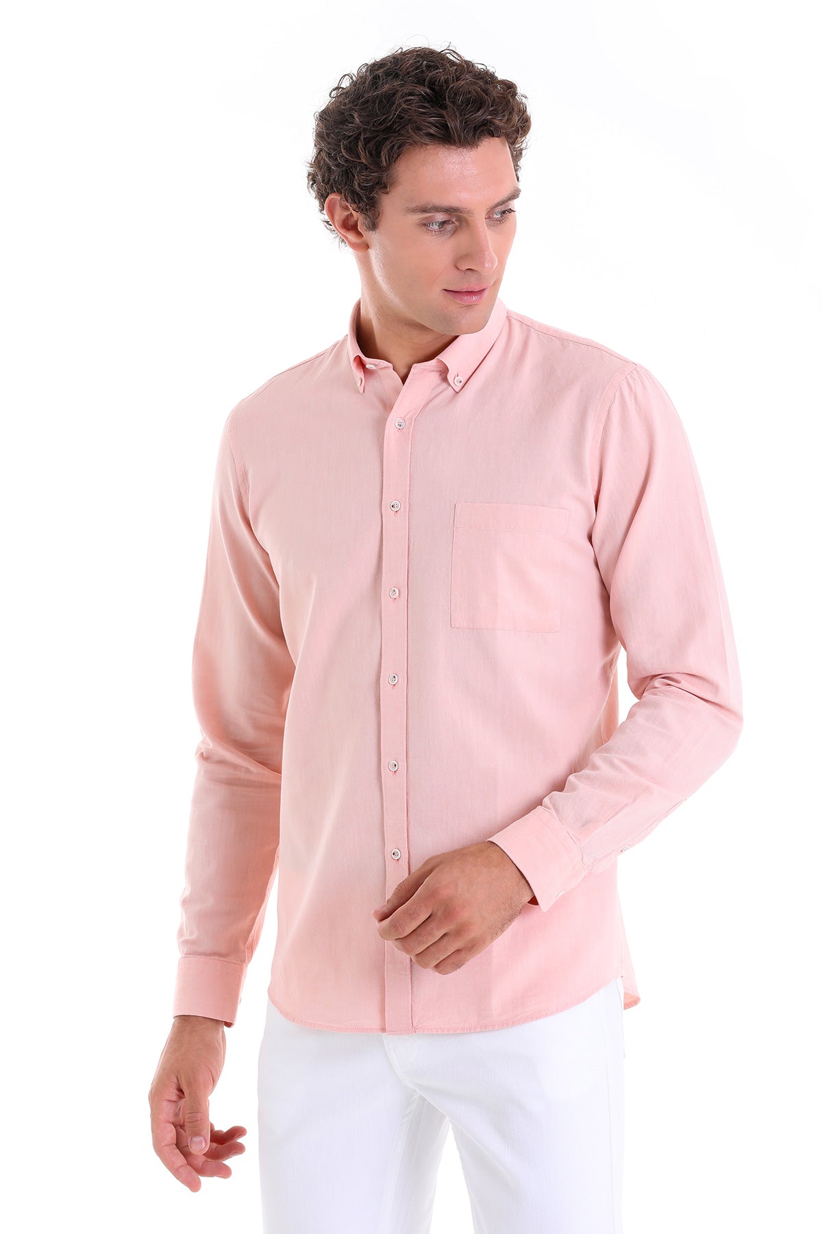 A man wearing a soft pink, long-sleeved button-down shirt with a classic collar and chest pocket.