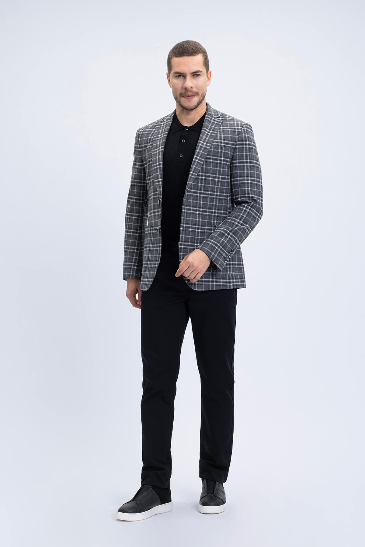 Men’s gray and white plaid comfort fit notch lapel blazer with classic double-breasted design worn over black polo
