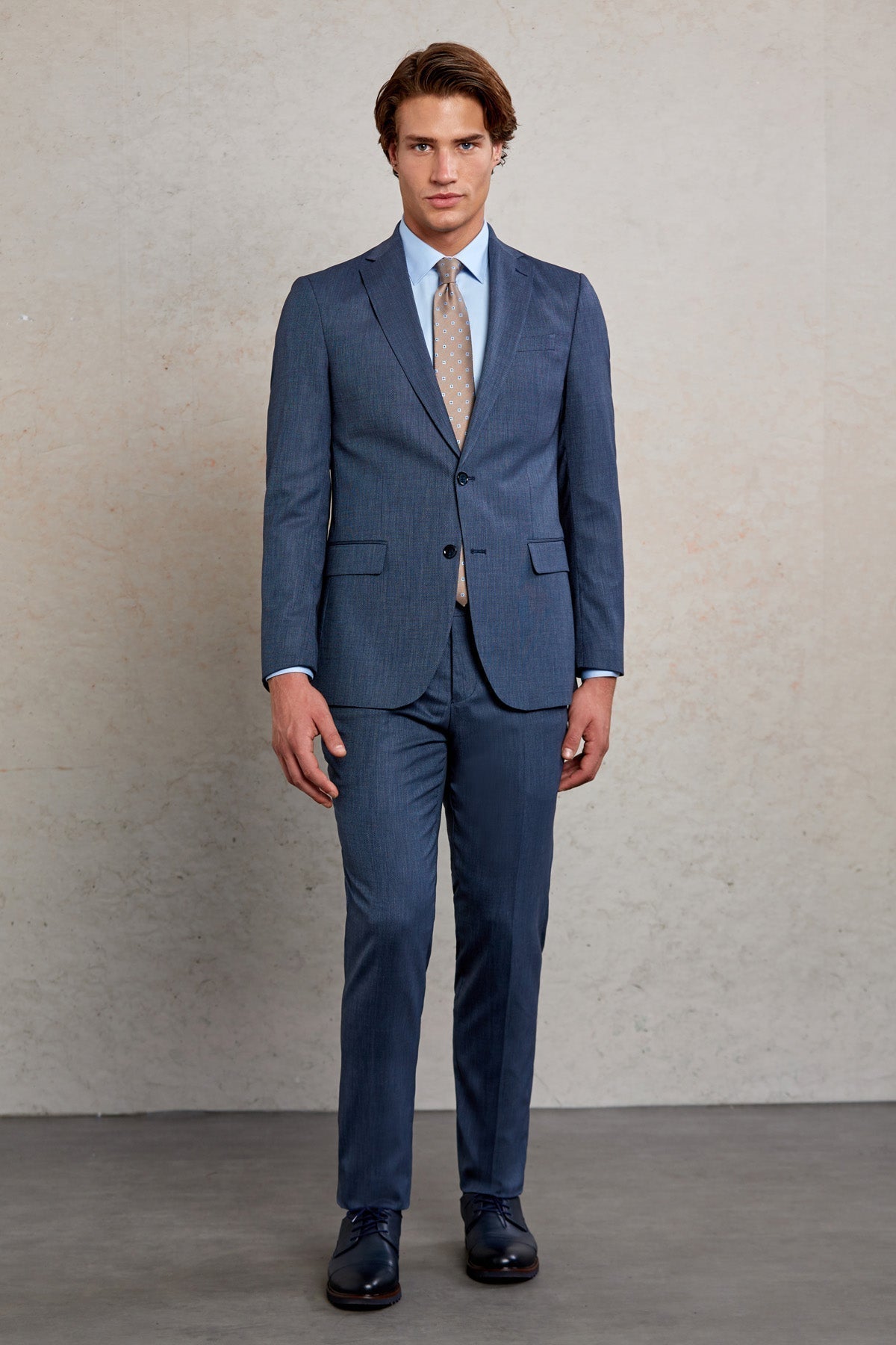 A tailored navy blue suit with a subtle pinstripe pattern, featuring a classic two-button jacket and matching trousers.