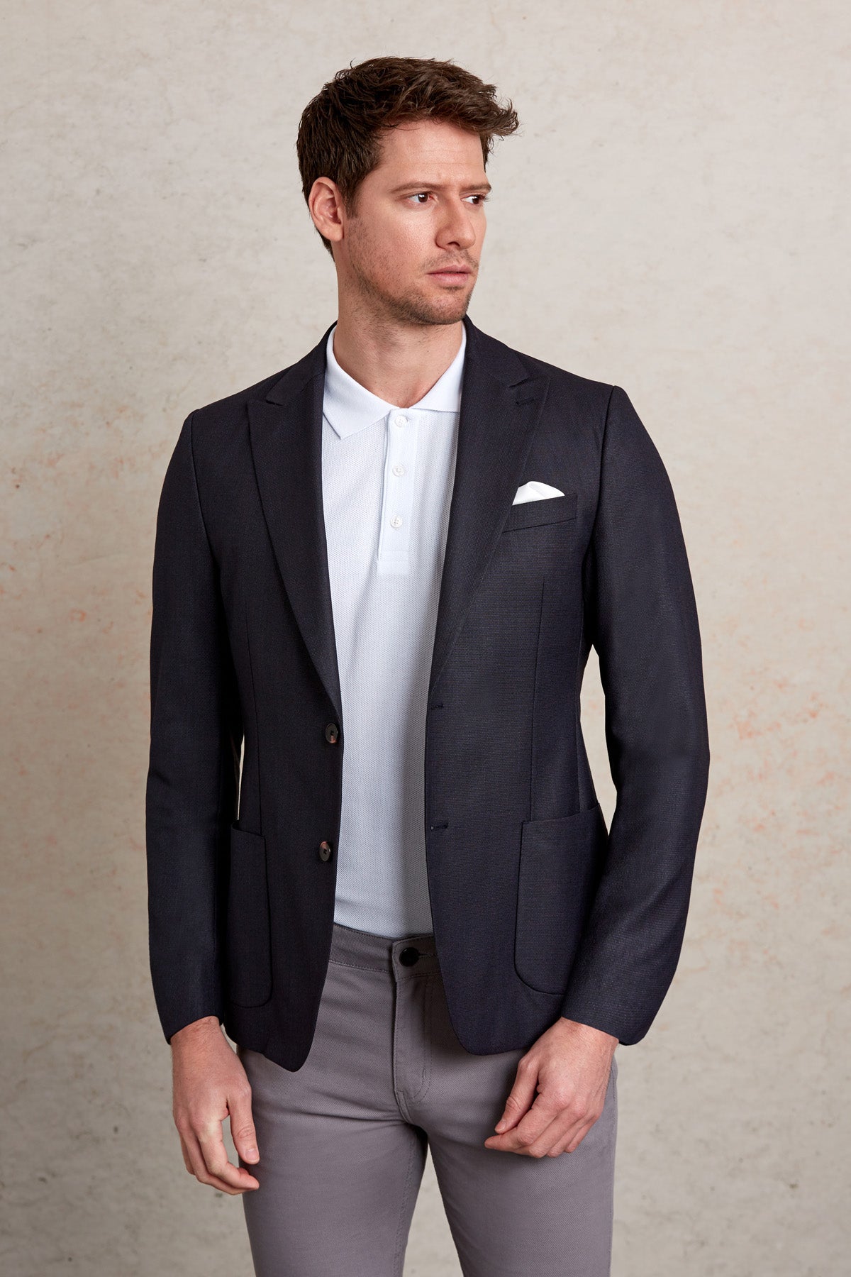 Navy blue tailored blazer with a crisp white pocket square and subtle texture