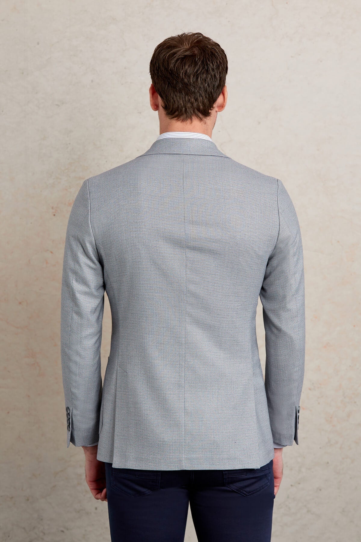 A light gray blazer with a subtle textured pattern, featuring classic tailored lines and buttoned cuffs.