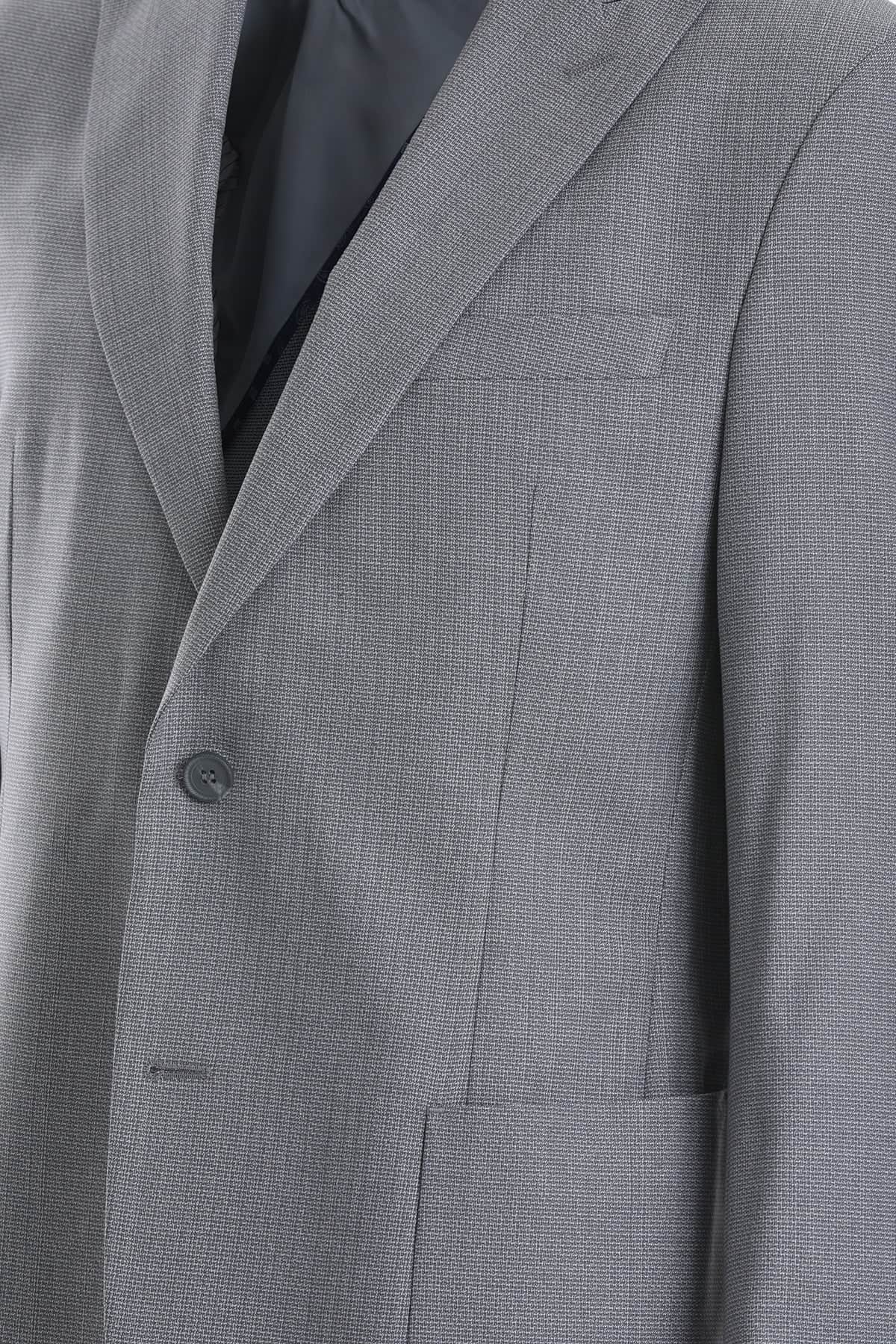 Gray textured wool suit jacket with subtle herringbone pattern and dark gray button.