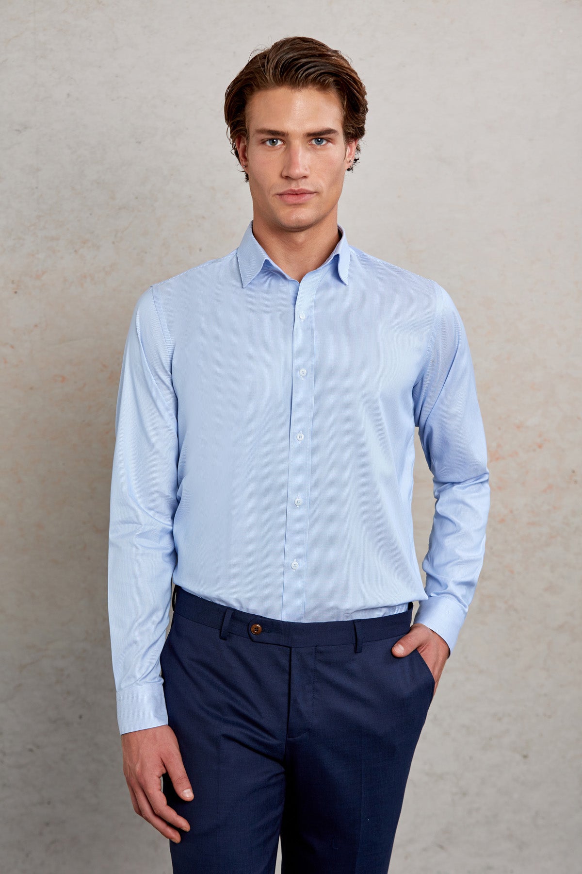 Light blue, long-sleeved men’s dress shirt with a classic collar and button-down front.