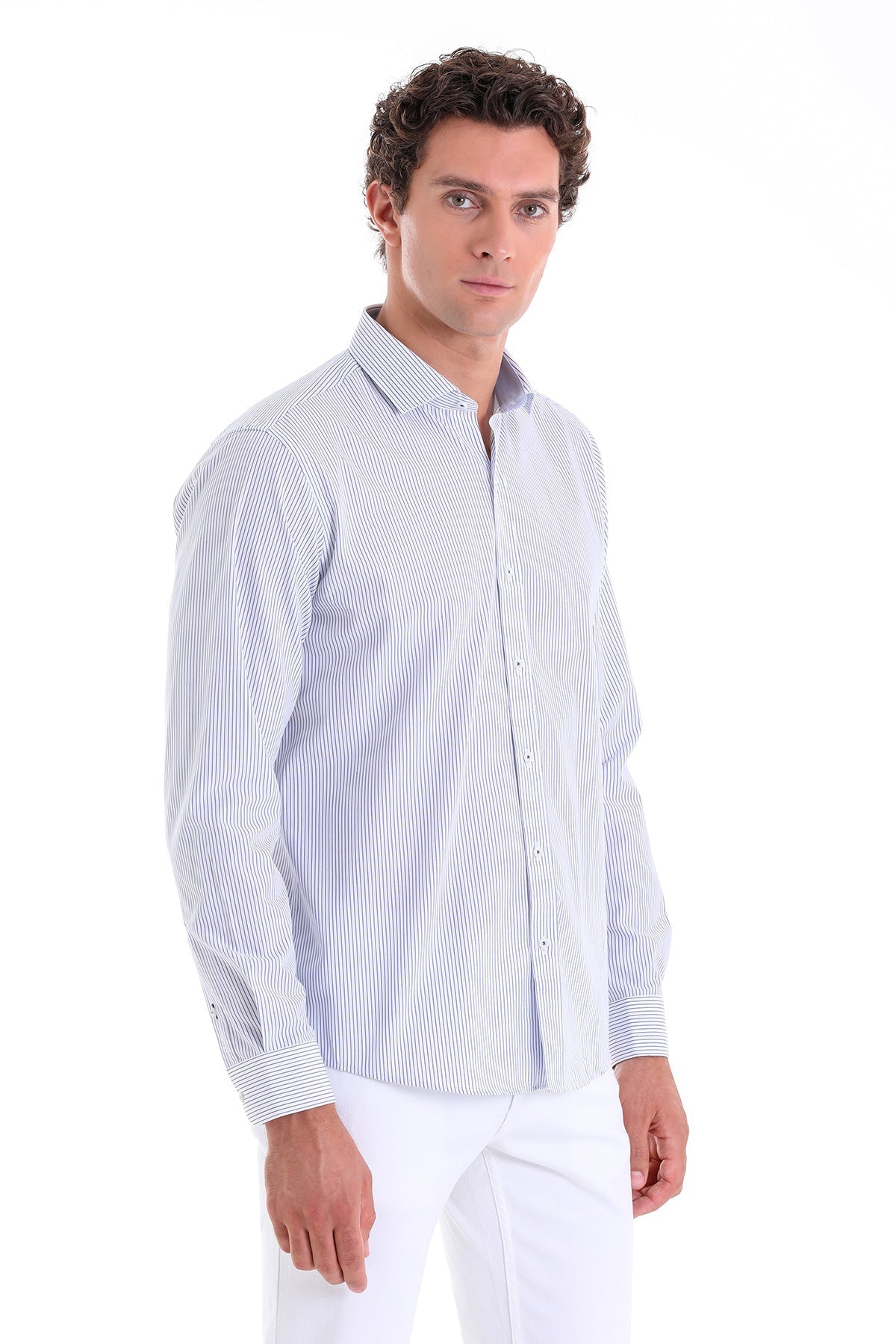 A man wearing a light blue and white vertically striped long-sleeved button-up shirt.