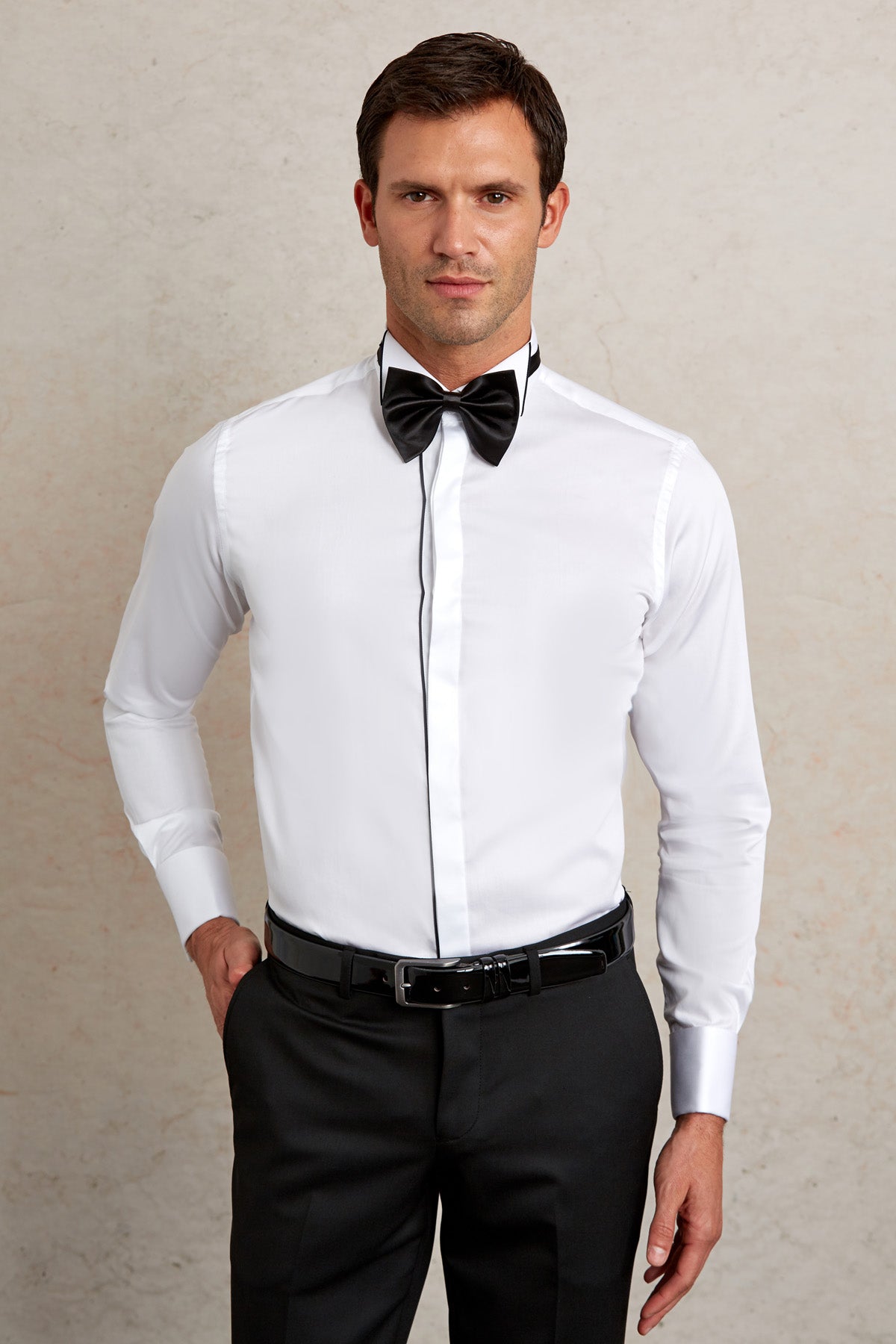 White dress shirt with black trim along the placket and cuffs, paired with a matching black bow tie.
