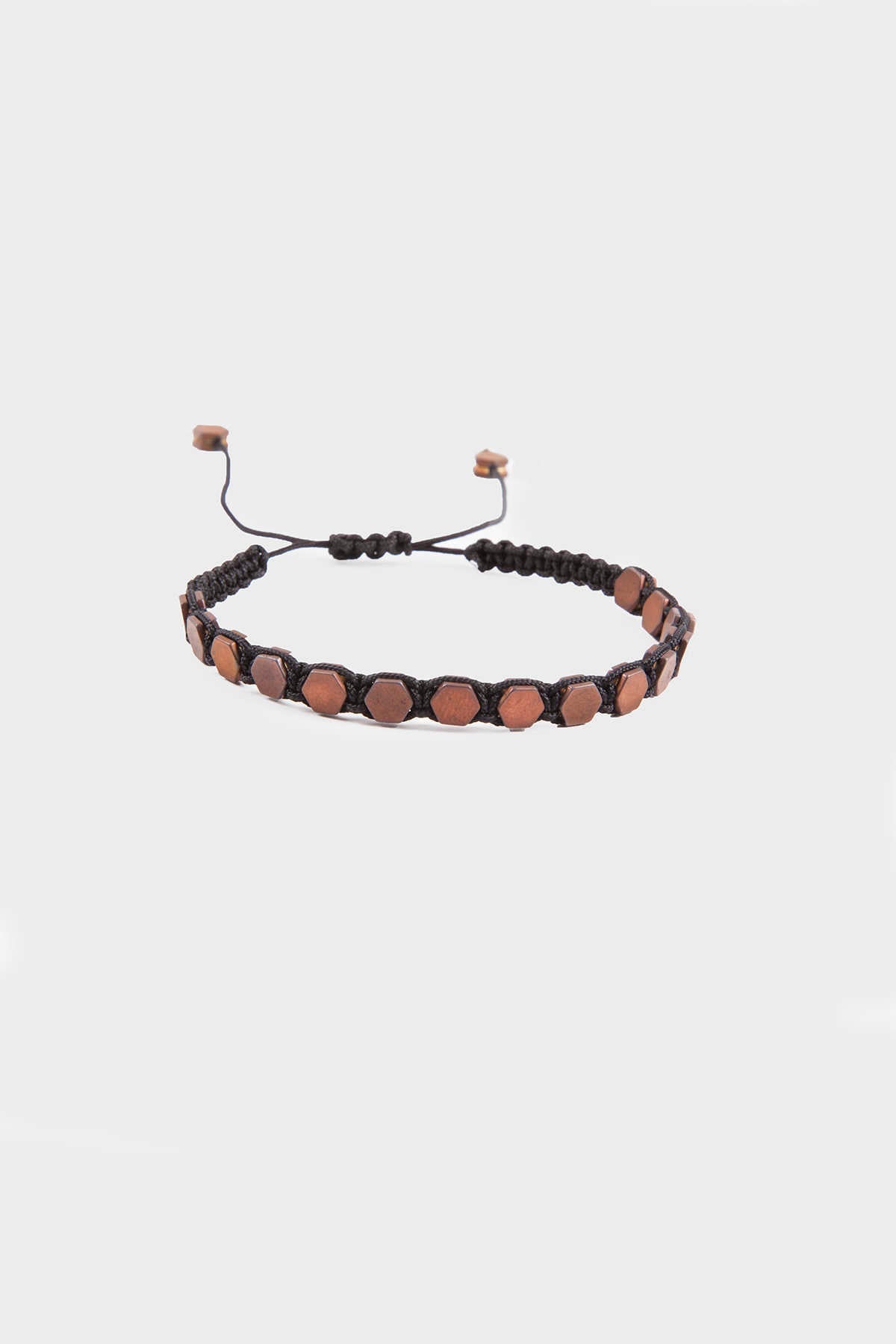 Black macrame bracelet adorned with hexagonal copper-toned beads and adjustable sliding knots.