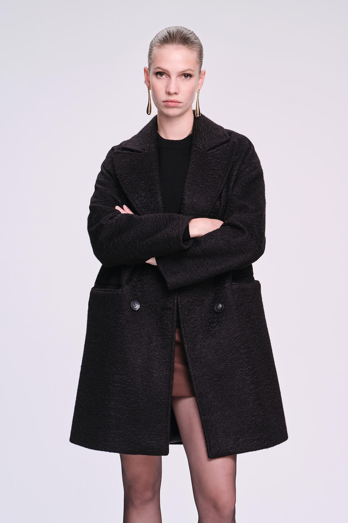 Black double-breasted coat with a textured, wool-like fabric and classic notched lapels.