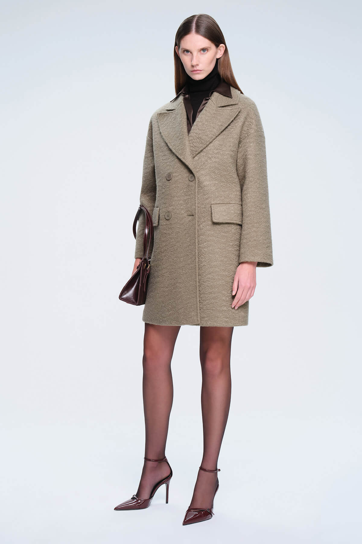 A taupe textured wool double-breasted coat with a classic collar and flap pockets.