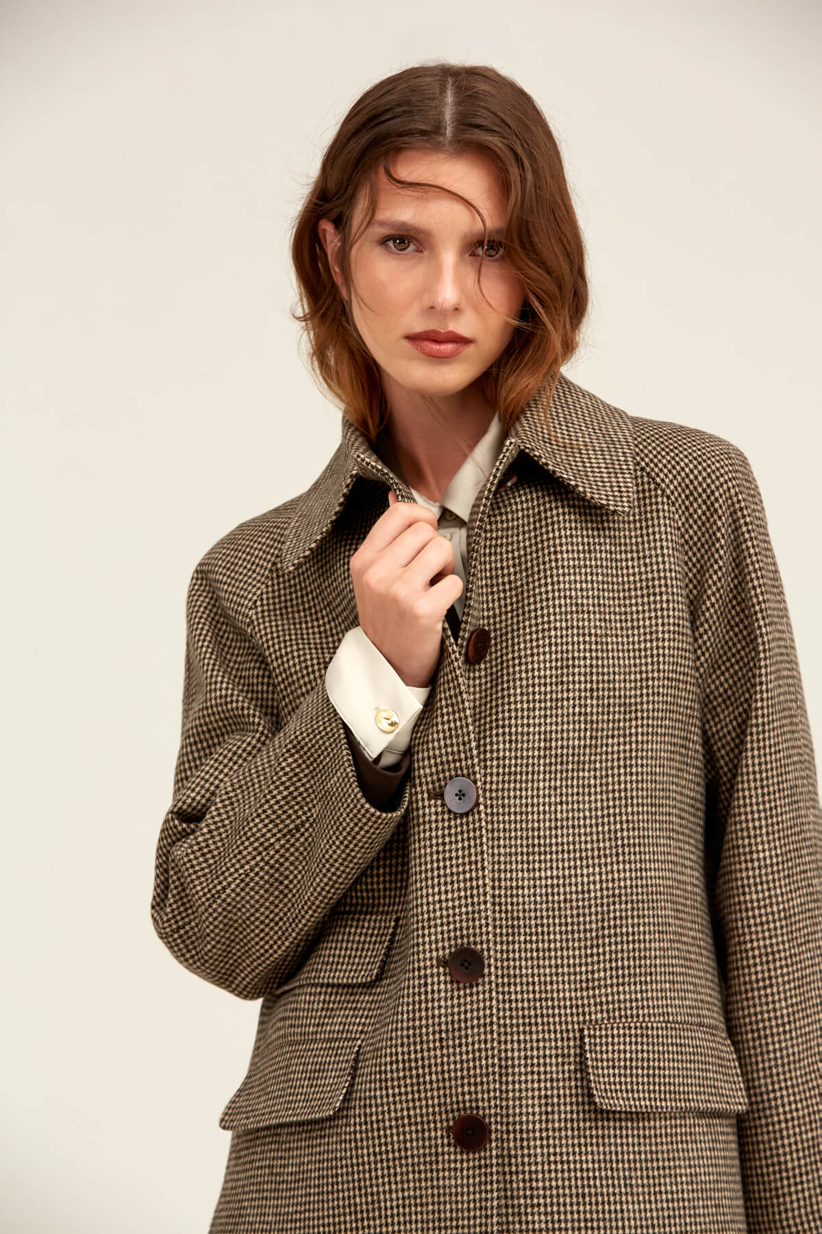 Brown and beige houndstooth wool coat with dark brown buttons.