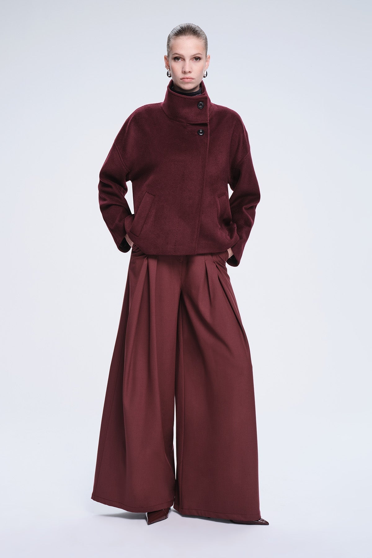 A rich burgundy woolen coat with a high collar and black buttons.