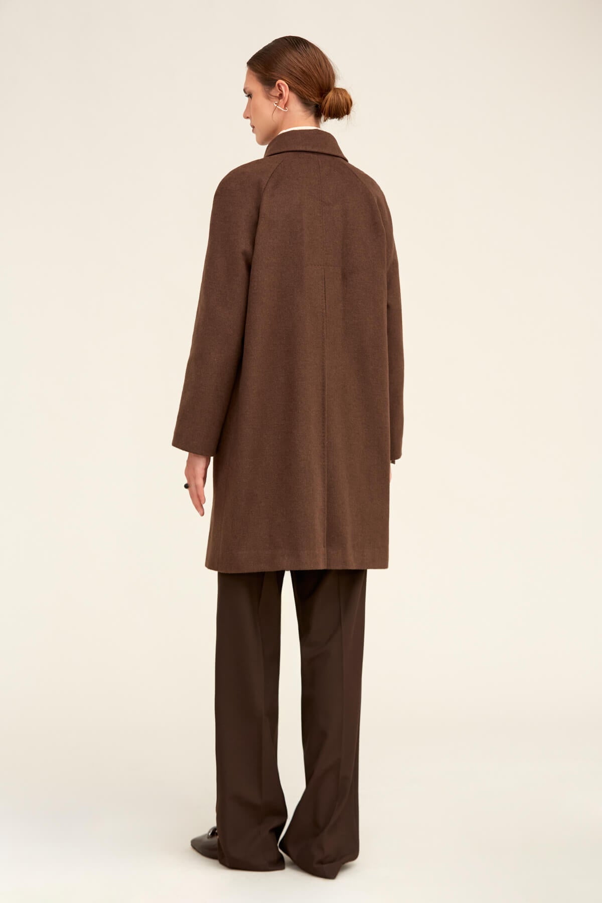 A sleek, chocolate-brown wool coat with a classic collar and straight-cut silhouette.