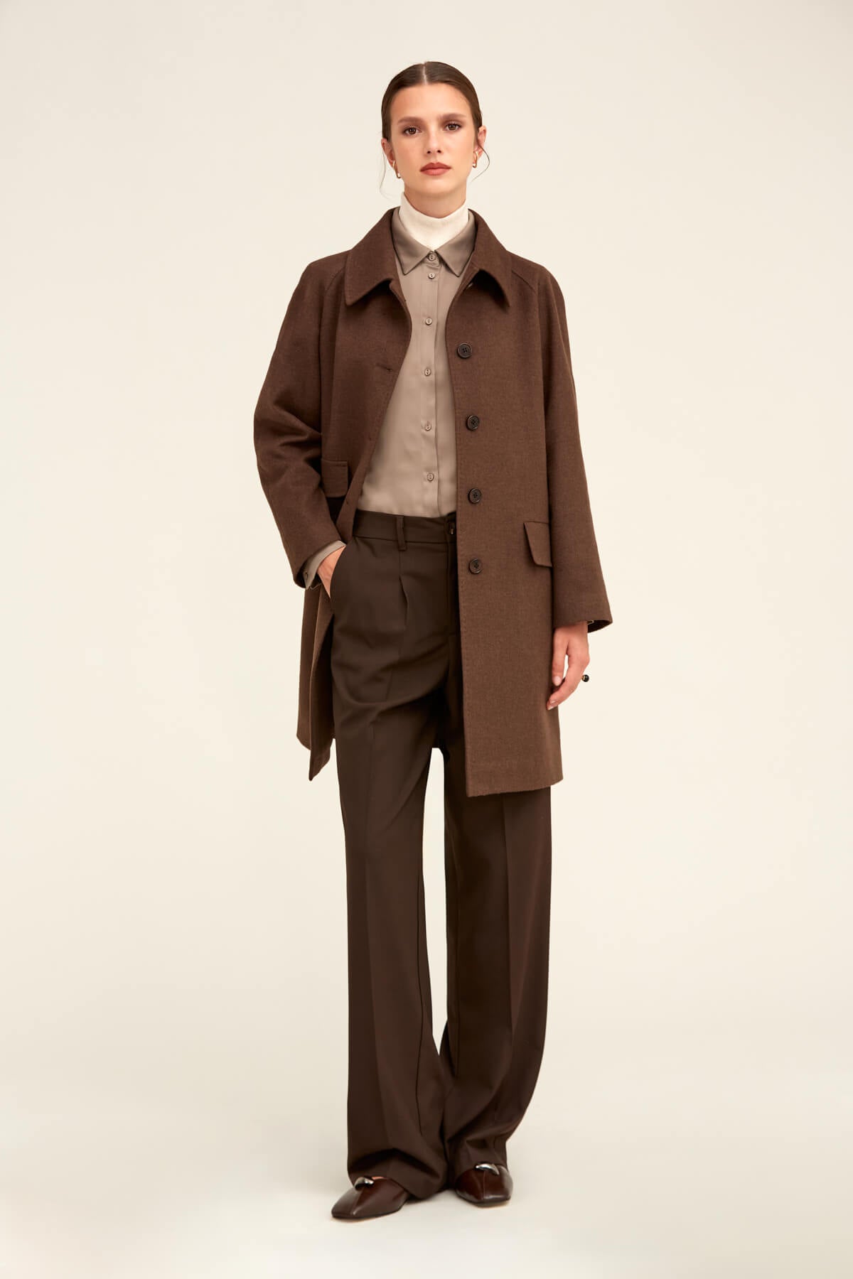 Brown woolen trench coat with a classic collar and buttoned front.