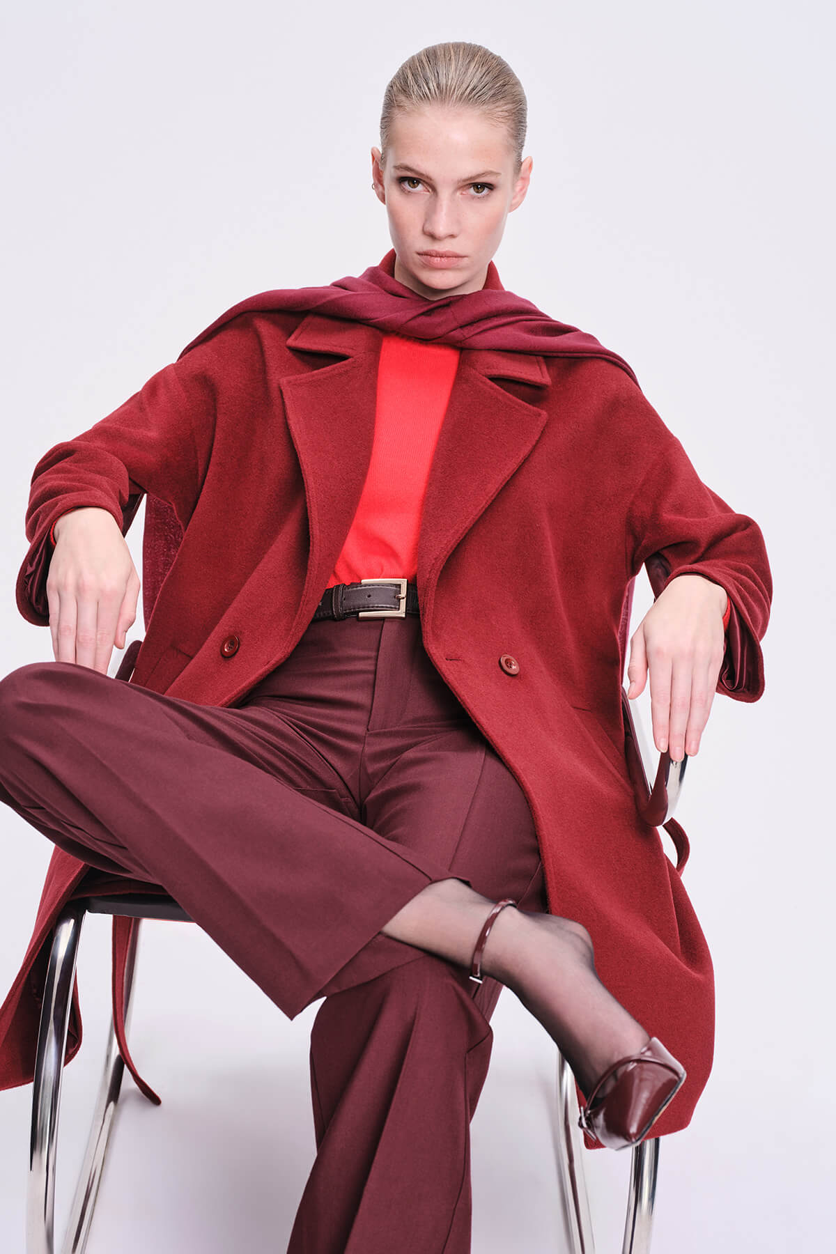 A rich red velvet coat with a draped collar and matching button closures.
