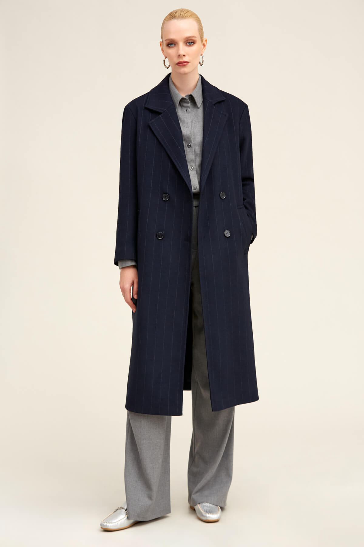 Navy blue double-breasted wool coat with notched lapels and dark buttons