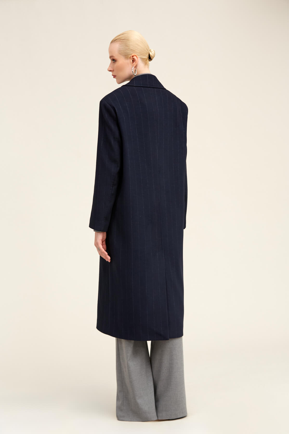 Navy blue wool overcoat with a structured collar and straight-cut silhouette