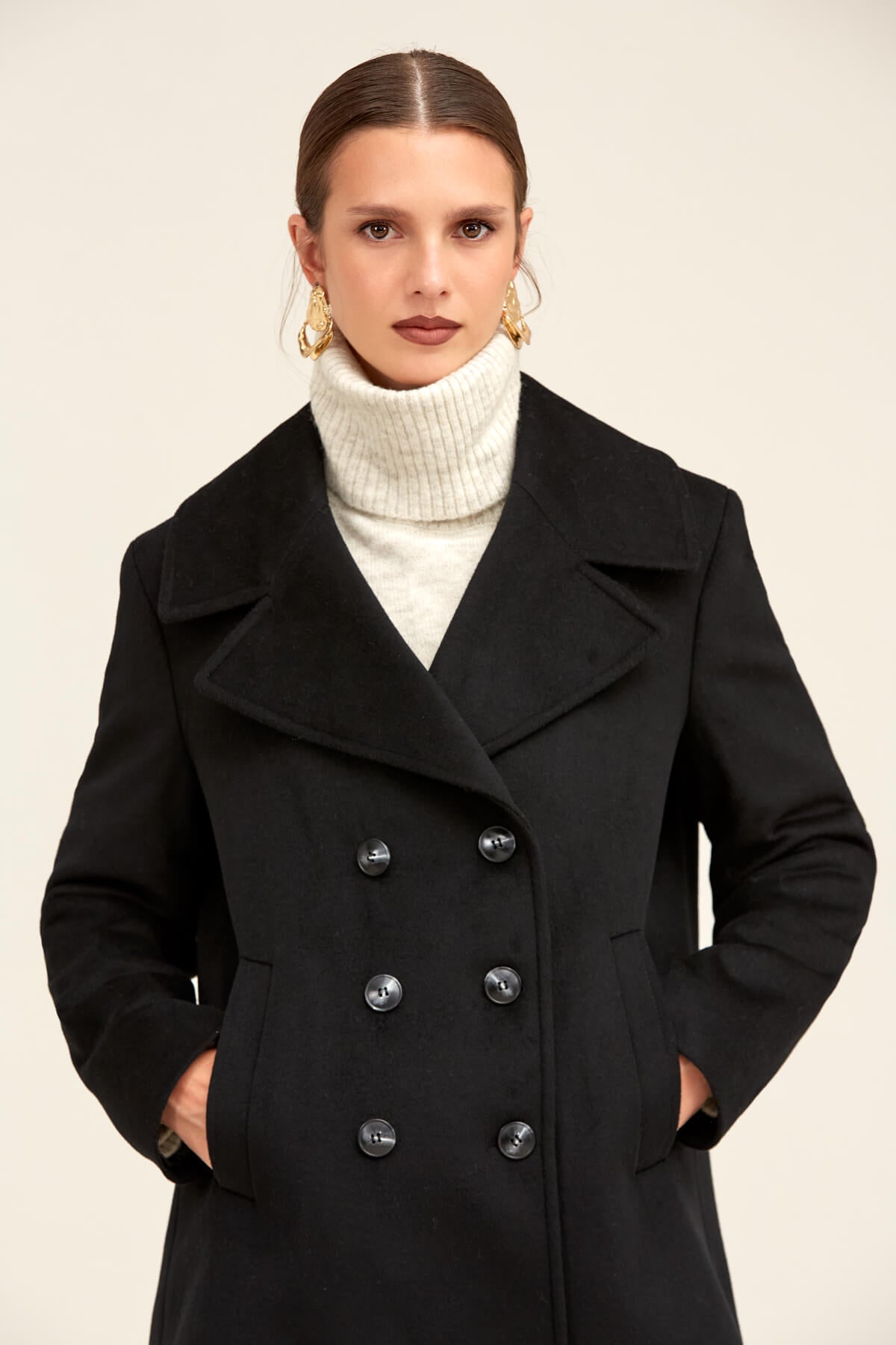 Black double-breasted wool coat with silver-toned buttons and notched lapels.