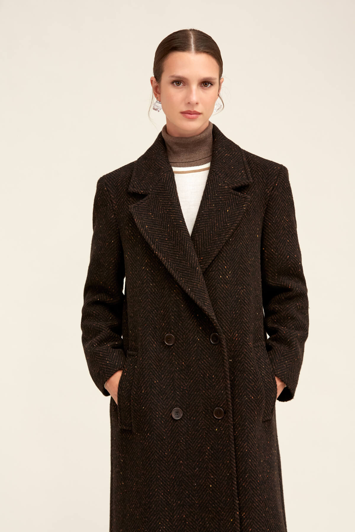 Black herringbone wool coat with a double-breasted design and dark buttons.