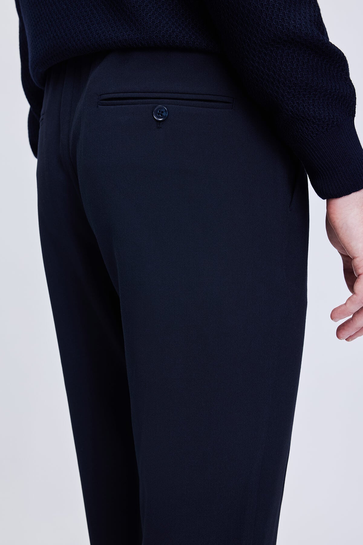 Black tailored trousers with a sleek, straight-leg cut and a subtle buttoned back pocket.