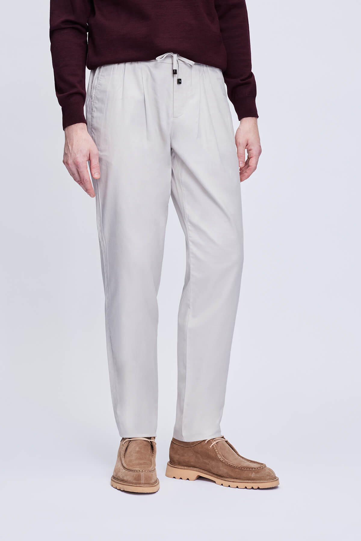 Light gray pleated chino pants with a drawstring waistband.
