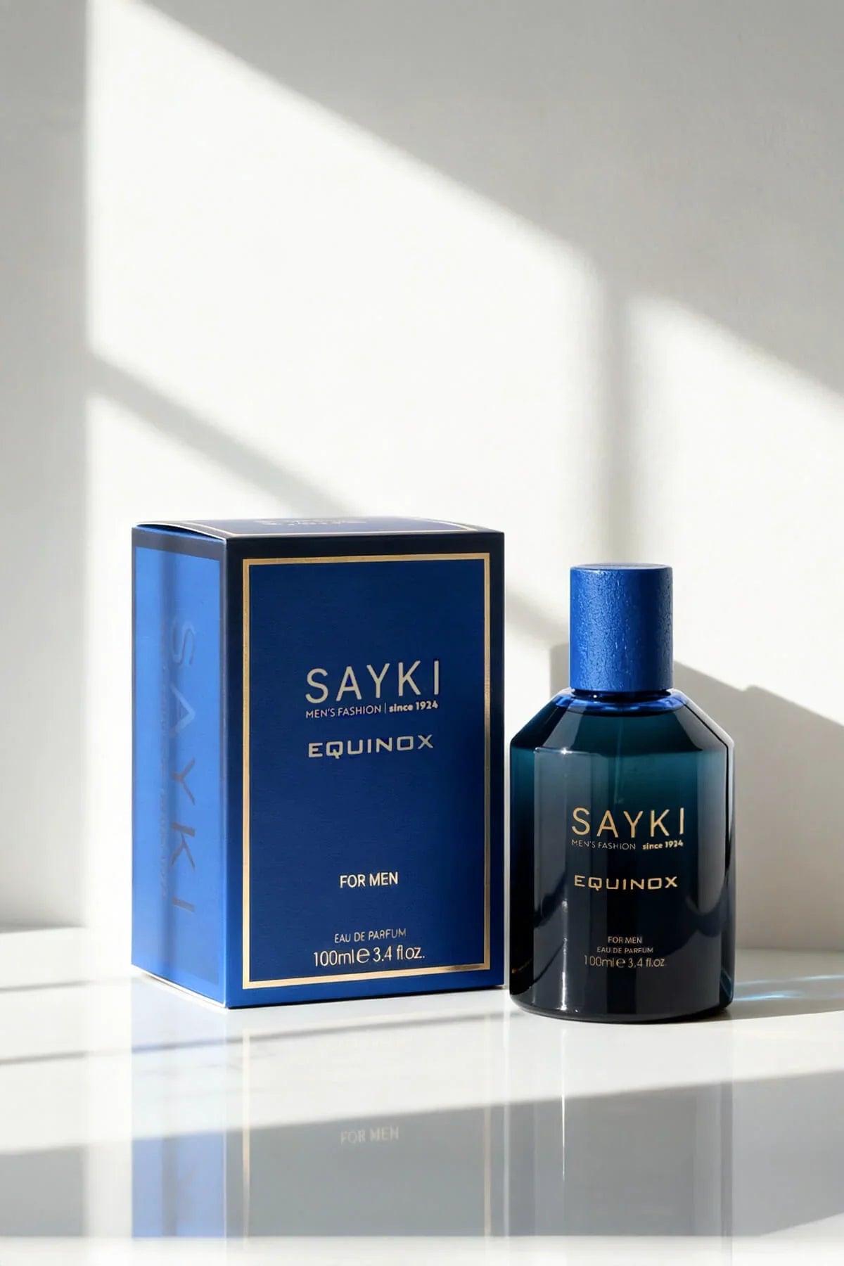 Deep blue glass bottle of sayki equinox men’s eau de parfum 100 ml with matching cap beside navy-blue box