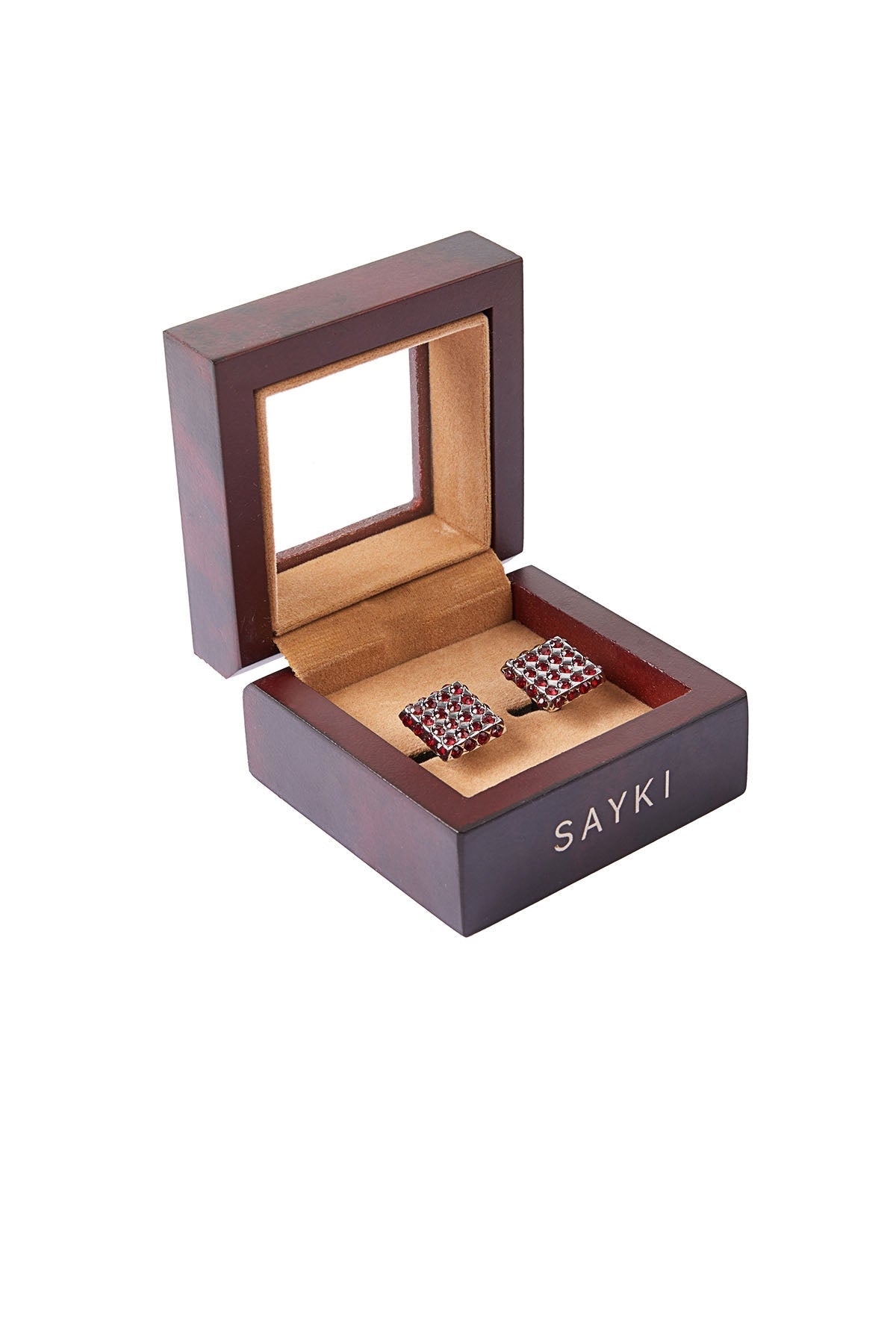 Square-shaped burgundy gemstone cufflinks nestled in a dark wood presentation box with the brand name ’sayki’ engraved on its side.