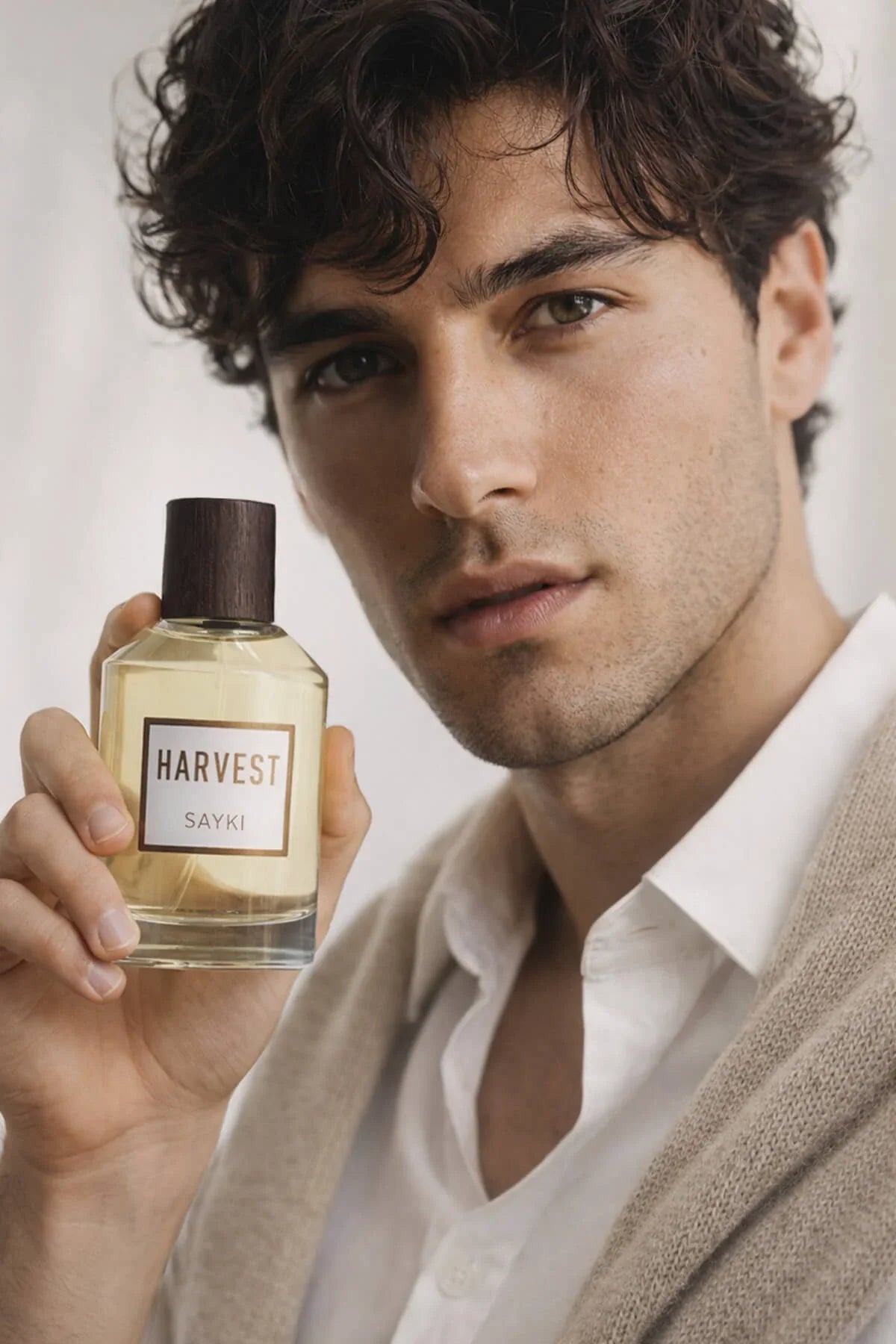 A clear glass bottle of harvest mens eau de parfum 100 ml with amber fragrance and dark wooden cap with minimalist label