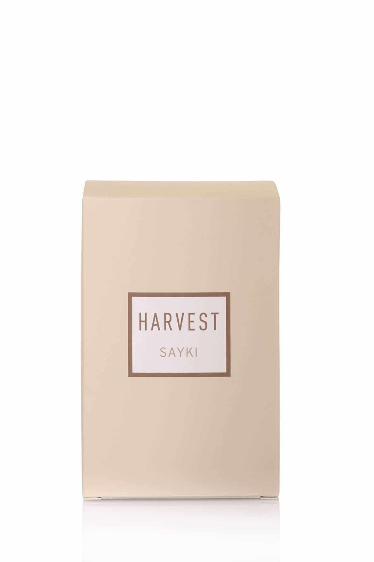 A clear glass bottle of Harvest men’s eau de parfum 100 ml with dark wood cap and pale yellow liquid