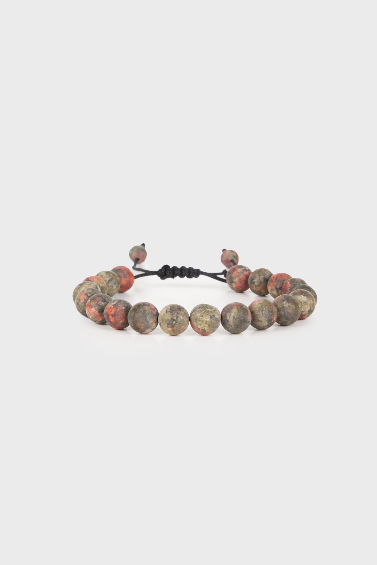 A beaded bracelet featuring round, earthy-toned stones with red and gray marbled patterns strung on a black adjustable cord.