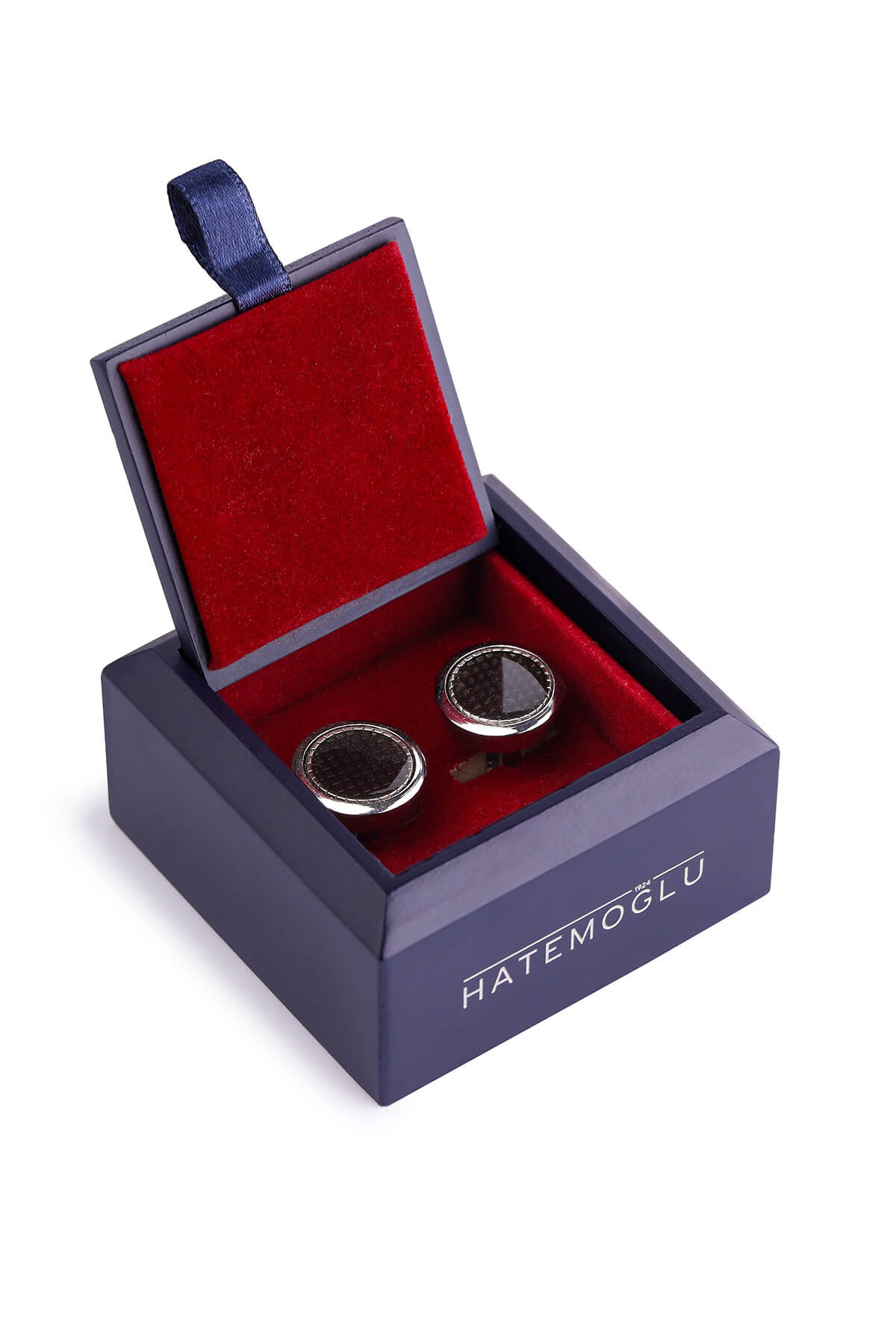 Silver-toned cufflinks with dark, circular inlays sit nestled inside a navy blue velvet-lined box.